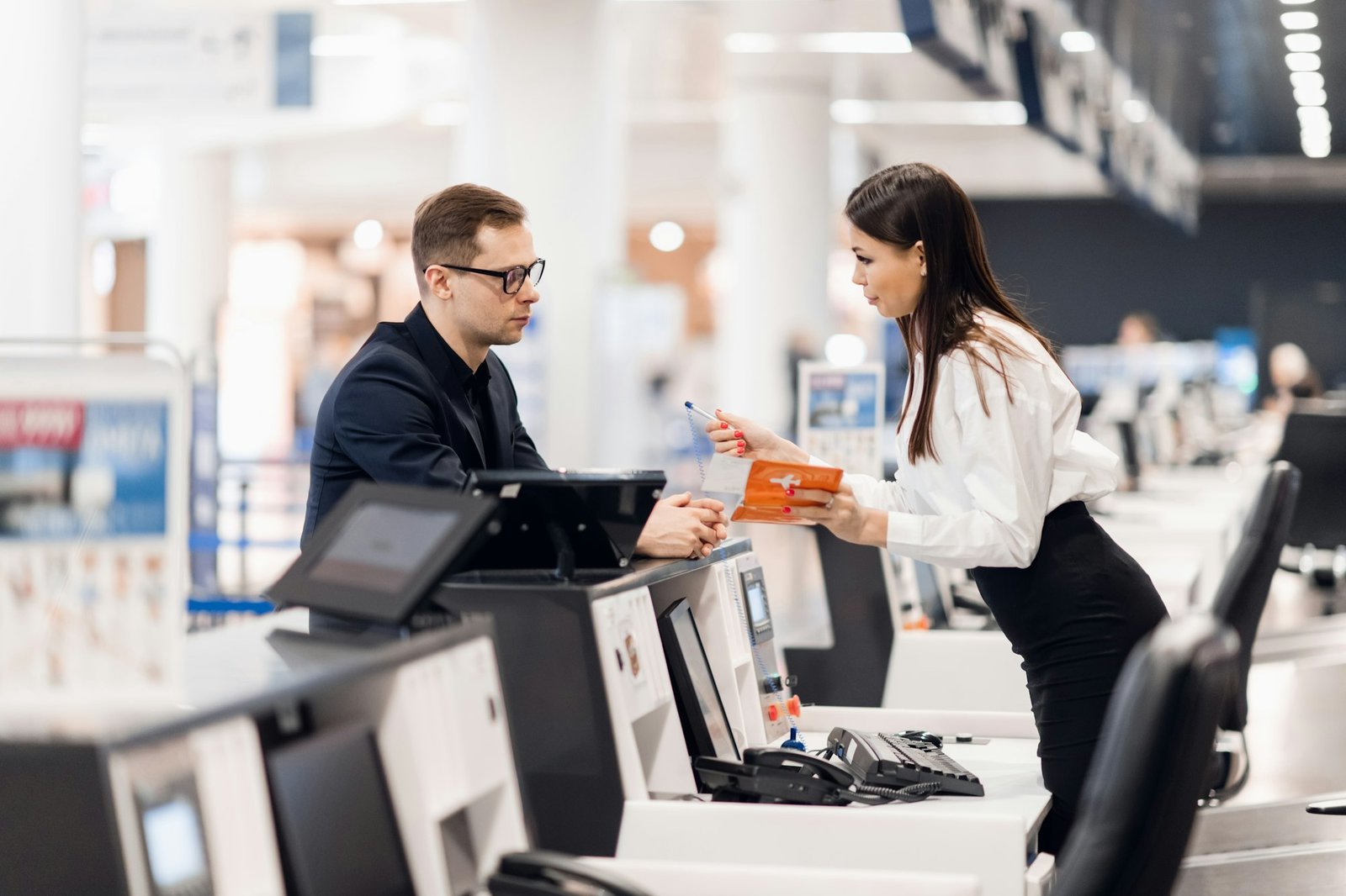 handsome businessman handing over air ticket at airline check in counter