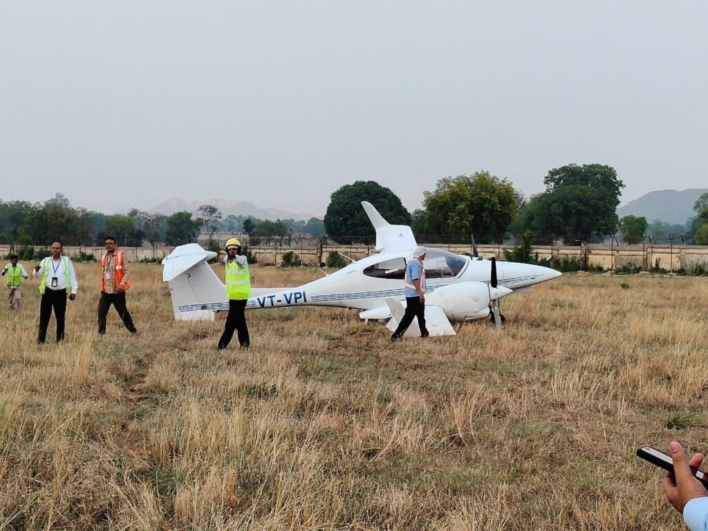 Khajuraho, India: A training aircraft operated by the Indian Flying Academy made an emergency landing at Khajuraho Airport on Tuesday after experiencing a serious technical snag involving the landing gear. The incident occurred during a routine flight training sortie and has since triggered a regulatory probe by India’s Directorate General of Civil Aviation (DGCA). According to airport authorities and official sources, the training aircraft encountered a malfunction in its rear right landing gear shortly after takeoff. In response, the crew chose to remain airborne for nearly two hours in a holding pattern. This decision was made to reduce the onboard fuel load and minimize the risk of fire during the emergency landing. As part of standard emergency protocol, foam was sprayed on the runway to further enhance safety conditions for the returning aircraft. The aircraft landed on two functional wheels at around 3:40 PM. Upon touchdown, the aircraft skidded off the runway due to the failed gear, but both the flight instructor and trainee pilot on board escaped unharmed. The situation was promptly brought under control by the airport's emergency response teams. No fire was reported, and there was no disruption to commercial operations at the airport following the incident. Authorities from the DGCA have confirmed that an investigation is underway to determine the root cause of the landing gear failure. Preliminary reports suggest that the crew followed all necessary safety protocols and managed the situation with composure and professionalism, thereby avoiding a major accident. This incident brings renewed focus to safety practices at Indian flying schools, which have been under increased scrutiny. The DGCA has recently emphasized the importance of standardizing training operations across flight academies and ensuring that infrastructure, aircraft maintenance, and instructor qualifications meet rigorous aviation standards. Additionally, new transparency directives now require flying schools to publicly disclose their fleet details, student-instructor ratios, and CPL training timelines, allowing students and parents to make informed decisions. While no injuries were reported in the Khajuraho emergency, the event serves as a reminder of the real-time challenges faced in flight training environments and the critical importance of emergency preparedness. The Indian Flying Academy has not yet released a detailed statement but is said to be cooperating fully with regulatory officials in the ongoing inquiry. Further updates will follow as the investigation progresses.