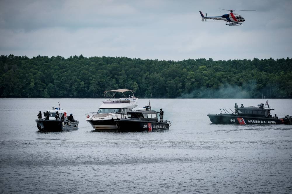 Johor, Malaysia: A Royal Malaysia Police (RMP) helicopter crashed into Sungai Pulai during a multinational security exercise on Thursday morning, injuring five officers. As of Friday morning, two of the injured remain in critical condition, while three are reported stable and under observation at Sultanah Aminah Hospital in Johor Bahru. The incident occurred during a ceremonial fly-past as part of the Multilateral Nuclear Security Detection Exercise (MITSATOM 2025), which involves participation from Malaysia, Singapore, Indonesia, and Thailand. The Airbus AS355N helicopter, registered 9M-PHG, took off at 9:51 AM from the Tanjung Kupang Police Station and nosedived into the river approximately 46 minutes later, near a jetty in Gelang Patah. Condition of Crew Members The five officers onboard were quickly rescued by marine police units present at the scene. They were immediately transferred to hospital for emergency medical care. According to the Royal Malaysia Police, the following personnel were on board: ACP Faizul Mohammad (pilot) Supt Ahmad Bustamin Baharom (co-pilot) Insp Muhammad Yusri Hamzah (observer) Sgt Mohd Firdzus Zulkifli L/Kpl Mohammad Farid Fikri Mat Noor The Inspector-General of Police confirmed that two officers are in critical condition and receiving respiratory support in the Intensive Care Unit, while the remaining three are stable. Investigation and Safety Review The Civil Aviation Authority of Malaysia (CAAM) has initiated a formal investigation into the crash in accordance with Part XXVI of the Civil Aviation Regulations 2016. The case has been transferred to the Air Accident Investigation Bureau (AAIB) under the Ministry of Transport. Authorities are currently focused on recovering the helicopter's black box and flight data recorders. The wreckage remains partially submerged, and recovery operations are ongoing. The helicopter involved in the crash was an Airbus AS355N model, which has been in service with the police since 1996. Following the incident, a dedicated technical committee has been formed to assess the viability of the AS355N fleet and determine whether the aircraft model should continue operating within the police force. Official Statements and Inter-Agency Coordination The Ministry of Science, Technology and Innovation (MOSTI) has confirmed its full cooperation with the investigation. In a public statement, the ministry said it will support the authorities in examining all safety and procedural aspects linked to the incident. No fatalities have been reported. The swift response by marine units and on-site personnel was instrumental in the immediate rescue of all five crew members. Further updates will be provided following the conclusion of the investigation and medical assessments.