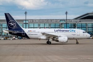 Germany: Germany is moving to reverse last year’s aviation tax increase, a step that could make flying from the country more affordable and strengthen its position as a leading European air travel hub. The federal government is considering undoing the levy imposed in May 2024, which raised departure charges on short-haul flights from €12.48 to €15.53, alongside similar increases for medium- and long-haul flights. If approved as part of the 2026 federal budget, the reversal is expected to come into effect ahead of the peak summer travel season, potentially lowering ticket prices for millions of passengers. The 2024 hike was introduced as a fiscal measure to boost government revenue and encourage climate-friendly travel. However, it immediately drew criticism from airlines and tourism advocates who warned it undermined Germany’s competitiveness and pushed airlines to cut capacity or withdraw routes altogether. Low-cost carriers such as Ryanair reduced services at several German airports, while tourism officials, including federal tourism coordinator Christoph Ploss, urged the government to reduce both aviation taxes and airport charges to restore confidence in the market. Rolling back the increase faces significant fiscal and political challenges. The levy contributes approximately €500 million in additional annual revenue, and officials have yet to identify alternative sources to offset the shortfall. As per Reuters a senior government source recently noted that while the aviation sector requires relief, the reversal is “not currently a priority” amid tight public finances and rising defense spending commitments. The debate is also complicated by environmental concerns, with critics warning that cheaper airfares could stimulate higher passenger volumes and increase emissions. In response, government sources have indicated that any tax reform may be paired with sustainability initiatives, including incentives for airlines to use sustainable aviation fuels and invest in cleaner fleets. Despite these challenges, industry groups believe a tax rollback would provide immediate benefits, restoring passenger growth and route development that were disrupted by the 2024 hike. It could also help German airports compete more effectively with hubs in neighboring countries that have maintained or lowered their aviation levies. Major carriers such as Lufthansa and Eurowings, as well as low-cost operators, are closely watching the budget process, which will determine whether the rollback is implemented in full or in phases. The Bundestag is expected to debate the proposal later this year as part of the 2026 budget negotiations. If passed, passengers could see cheaper tickets as early as 2026, a change likely to influence booking patterns and airline strategies for the coming years. The government faces the difficult task of balancing consumer benefits and industry competitiveness with environmental targets and fiscal stability, but the outcome of this reform could mark a significant shift in Germany’s aviation policy.