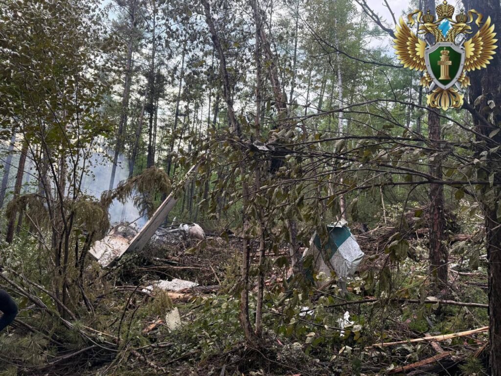 Tynda, Russia: A passenger aircraft operated by Angara Airlines crashed during its final approach to Tynda Airport in Russia’s Amur region on Wednesday, killing all 48 people on board. The crash occurred amid poor weather conditions and has prompted an official investigation by multiple federal and regional agencies. Aircraft Disappeared from Radar During Second Approach According to a statement from Rosaviatsiya, Russia’s Federal Air Transport Agency, the Antonov An‑24 aircraft was conducting a scheduled domestic flight from Blagoveshchensk to Tynda when it vanished from radar during a second landing attempt at approximately 10:30 a.m. local time. No distress call was issued by the flight crew prior to disappearance. The aircraft was located approximately 15 kilometers south of Tynda Airport, in heavily wooded terrain. Aerial reconnaissance by a Mi-8 helicopter from the Russian Emergencies Ministry visually confirmed the wreckage and noted that the fuselage was engulfed in flames at the time of discovery. Rescue teams were dispatched to the crash site by ground due to smoke and poor visibility preventing helicopter landings. No Survivors; Emergency Response Mobilized The Amur Regional Governor, Vasily Orlov, confirmed through an official statement that all 48 occupants (42 passengers and 6 crew members) perished in the accident. Among the deceased were five children. The Russian Emergencies Ministry deployed over 149 personnel and 21 units of equipment to the scene. The search and recovery operations have been hampered by steep terrain, dense forest cover, and lack of direct road access to the crash site. Authorities reported the fire had been extinguished by the time rescue teams reached the fuselage. Governor Orlov announced three days of official mourning in the Amur region beginning July 25. He also stated that psychological support services and family coordination centers have been established for the victims’ relatives. Criminal Investigation Launched The Investigative Committee of the Russian Federation has opened a criminal case under Article 263 of the Criminal Code, which addresses violations of transportation safety rules that result in fatalities. In a statement, Committee spokesperson Svetlana Petrenko confirmed that forensic experts, flight safety inspectors, and federal investigators have been dispatched to collect evidence from the site. The Far Eastern Transport Prosecutor’s Office is overseeing compliance with aviation safety protocols and maintenance documentation related to the flight and the airline. A joint technical commission has been formed to inspect aircraft logs, air traffic communication records, and crew qualifications. Aircraft Details and Maintenance Records The aircraft involved in the crash was a twin-engine Antonov An‑24, manufactured in 1976. Though several decades old, it was confirmed by Rosaviatsiya and Angara Airlines that the aircraft had passed its most recent technical inspection and was deemed airworthy. However, public records indicate that the aircraft had been involved in at least four minor incidents since 2018, including engine-related technical alerts. Investigators have not yet commented on whether previous mechanical issues may be linked to the crash. Russian President Vladimir Putin was briefed immediately following the incident. Kremlin spokesperson Dmitry Peskov stated that President Putin expressed condolences to the families of the victims and called for a comprehensive federal-level investigation. Prime Minister Mikhail Mishustin ordered the formation of a high-level commission to oversee the investigation and response. The commission will coordinate between federal aviation bodies, law enforcement, and the airline. The Prime Minister also instructed regional administrators to facilitate financial compensation and logistical support for next of kin. Preliminary Findings and Weather Conditions Although the final cause remains under investigation, initial assessments by emergency services and reported by TASS, Russia’s state news agency, suggest that crew error during landing in low-visibility conditions may have contributed to the crash. Visibility in the Tynda area was reported to be severely reduced due to fog and overcast conditions at the time of the attempted landing. Flight data recorders (black boxes) are being retrieved and will be analyzed by the Interstate Aviation Committee (IAC). No timeline has been issued for the preliminary report.