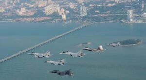 Kuantan, Malaysia: A Royal Malaysian Air Force (RMAF) F/A-18D Hornet fighter jet caught fire during take-off at Sultan Haji Ahmad Shah Airport on Thursday night, prompting both pilots to eject seconds before the aircraft crashed. The incident, which occurred around 9:05 pm, temporarily shut down the airport’s runway and disrupted several commercial flights. The RMAF confirmed in a statement that the twin-seat Hornet suffered a fire during its take-off roll at Kuantan Air Base. “Both pilots successfully ejected and were immediately transported to Tengku Ampuan Afzan Hospital for medical observation,” the Air Force said. Witnesses described the terrifying moment as the aircraft burst into flames, sending smoke billowing into the night sky. One resident said that two loud explosions “sounded like missile strikes” and could be heard nearly a kilometre away. A video of the incident, widely circulated on social media, shows the Hornet engulfed in flames as it attempted to lift off the runway before both crew members ejected. The Civil Aviation Authority of Malaysia (CAAM) declared a temporary “Code Black” runway closure following the accident. In a statement CAAM said the runway would remain shut until 1 pm on Friday, August 22, to facilitate debris clearance and safety checks. The closure affected several scheduled services, including Malaysia Airlines flights MH1268 and MH1269, and Scoot flights TR0470 and TR0471. Passengers were advised to check with their airlines for rebooking arrangements. Prime Minister Datuk Seri Anwar Ibrahim extended his well-wishes to the pilots and urged a comprehensive investigation into the cause of the fire. “This incident must be studied thoroughly to ensure the safety of our airmen and the reliability of our defence assets,” Anwar said, as quoted by Malay Mail. The RMAF has launched a formal probe into the accident. No casualties were reported on the ground, and authorities confirmed that the fire was contained within the air base perimeter. The Boeing F/A-18D Hornet is one of the RMAF’s frontline multirole fighters, acquired in the 1990s. The aircraft has seen extensive service, including participation in regional exercises and maritime patrols. The fleet is currently undergoing phased upgrades as part of Malaysia’s defence modernisation plan. While the immediate priority remains the health of the two aircrew, the investigation will focus on determining whether a mechanical failure, engine malfunction, or other technical issues caused the fire. The findings are expected to inform future operational safety measures for the RMAF’s combat fleet. In a separate incident a month ago, five police officers were injured when their AS355N helicopter crashed into the Pulai River during a nuclear security exercise in Johor. Two officers remain in critical condition and are receiving respiratory support in the Intensive Care Unit at Sultanah Aminah Hospital. The remaining three officers are stable. The Civil Aviation Authority of Malaysia (CAAM) confirmed the crash occurred near the Malaysian Maritime Enforcement Agency (MMEA) Jetty in Gelang Patah.
