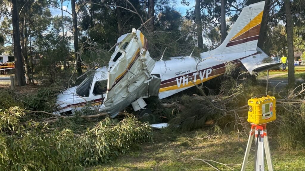 Sydney, Australia: A training flight ended in a dramatic emergency landing on Sunday afternoon when a light aircraft carrying a flight instructor and a student pilot crash-landed on the Mona Vale Golf Course in Sydney’s Northern Beaches. Both men survived with minor injuries, according to emergency officials.
The aircraft, identified as a Piper Cherokee, went down shortly after 2:00 p.m. during a scheduled training flight. Witnesses told ABC News Australia that the plane lost height quickly before skidding across the golf course, tearing off its landing gear and damaging one wing before coming to rest on the green.
Paramedics confirmed that both occupants, an instructor and his student, each believed to be in their 50s, managed to exit the wreckage without assistance. One suffered minor facial cuts while the other was treated for shock. Both were transported to Royal North Shore Hospital, where they remain in stable condition.
Nearby golfers rushed to the scene moments after the crash, providing initial assistance before emergency services arrived. Eyewitnesses described the landing as “hair-raising” but credited the instructor’s quick decision-making for avoiding a far more serious tragedy.
The Piper Cherokee had departed Camden Airport and was heading south towards Wollongong when engine trouble was suspected mid-flight. Investigators believe the pilot attempted to divert but was forced to make an emergency landing, selecting the golf course as the safest available option.
Video footage shared by multiple outlets,shows the aircraft gliding at low altitude before impacting the turf and skidding across the fairway. The landing gear collapsed on impact, and debris scattered across the course.
The Australian Transport Safety Bureau (ATSB) confirmed it had been notified and is gathering preliminary evidence. However, it is not yet clear whether a full on-site investigation will be launched.
