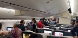 New Delhi, India: Over 200 passengers on board Air India’s Singapore-bound flight from Delhi faced a gruelling night after a cabin cooling failure delayed their departure by nearly six hours, forcing them to deplane and wait in the terminal before a replacement aircraft was arranged. The incident occurred on Flight AI2380, operated with a Boeing 787-9 Dreamliner, which was scheduled to depart Indira Gandhi International Airport at around 11:00 PM on Wednesday night. Shortly after boarding, the aircraft reportedly experienced faults with its air conditioning system and electrical power supply, resulting in rising cabin temperatures. According to passengers, the situation quickly became uncomfortable as the cabin’s temperature climbed. Several travellers shared videos on social media showing people fanning themselves with newspapers and magazines. Some posts described young children and elderly passengers struggling with the heat during the extended wait. Passengers remained inside the aircraft for close to two hours before crew instructed them to disembark and return to the terminal. The decision was taken after engineers determined the issue could not be resolved on the spot. In a statement, Air India acknowledged the disruption, citing a “cabin cooling issue on ground prior to departure” as the cause. The airline said that its ground teams provided regular updates, refreshments, and meals while travellers waited in the terminal. “We sincerely regret the inconvenience caused to our passengers. The safety and well-being of everyone on board remain our top priority,” the airline said. With the Dreamliner grounded for repairs, Air India deployed a replacement aircraft. The rescheduled flight finally took off at 5:36 AM IST on Thursday, nearly six hours behind schedule.