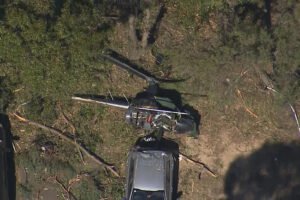 Sydney, Australia: A fatal helicopter crash occurred at Bankstown Airport in Sydney's south-west on Friday, when the helicopter Crashed into a car resulting in the death of a man and leaving a teenager in critical condition. At approximately 1:30 PM, emergency services responded to reports of a helicopter crash on Birch Street, near Bankstown Airport. Upon arrival, they found a man in his 50s deceased at the scene. A 19-year-old male, believed to be a student, sustained serious injuries. He was transported to Liverpool Hospital in critical condition. Witnesses reported hearing a loud noise and observing the helicopter struggling in the air before it crashed through multiple trees and landed on a parked car. One witness, who was in a nearby classroom, received a call from a friend who had heard the crash and rushed to the scene. They managed to pull the teenager from the wreckage, who was described as shaken but alive. The Australian Transport Safety Bureau (ATSB) is conducting a formal investigation into the cause of the crash. The incident occurred during a training flight, with the deceased man believed to be the instructor. The ATSB is expected to release a preliminary report within weeks, with a final investigation report to follow in the coming months.