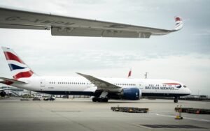 London, United Kingdom: A British Airways flight was canceled at London Heathrow Airport after a ground service vehicle became lodged under a Boeing 787 Dreamliner, causing significant damage and a 24-hour delay. The incident occurred on Monday evening at Terminal 5, where a van operated by Thales, an aviation technology firm, rolled beneath the aircraft's wing after its driver failed to engage the handbrake during pre-departure checks. The vehicle became wedged under the fuselage, leading to the cancellation of Flight BA33 to Kuala Lumpur over safety concerns. Approximately 300 passengers were affected by the cancellation, resulting in a 24-hour delay. They were provided with overnight accommodation while engineers and emergency services assessed the situation. The total cost of the incident, including safety checks, compensations, and revised crew schedules, was estimated at £100,000. British Airways confirmed the delay and provided accommodations, while Thales did not comment on the incident. For passengers affected by flight cancellations, British Airways offers assistance with delays, cancellations, and refunds. Passengers are advised to update their contact information in "Manage My Booking" to receive timely updates.