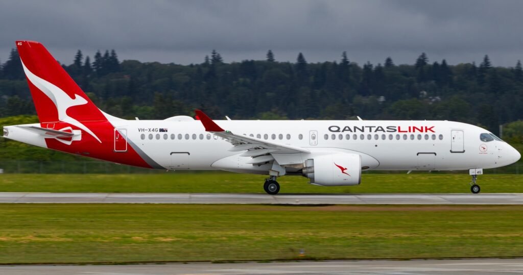 Canberra, Australia: QantasLink has announced plans to close its bases in Canberra, Hobart, and Mildura by April 2026, affecting approximately 70 pilots and cabin crew members. The airline states that this decision follows a comprehensive review aimed at consolidating operations to enhance service reliability, especially with the introduction of new aircraft like the Airbus A220 and Q400 turboprops. In response, the Transport Workers Union (TWU) has strongly criticized the move, arguing that it prioritizes profits over people and will harm regional communities and staff stability. A survey conducted by the TWU, Australian and International Pilots Association (AIPA), and the Australian Federation of Air Pilots (AFAP) found that 68% of affected pilots would need to consider other employment if the bases closed, with one in five already impacted by recent closures in Perth and Cairns. The closures come as QantasLink posted near-record profits of $2.39 billion. The airline was recently fined a record $90 million by the Federal Court for illegally outsourcing 1,800 ground workers. Despite the base closures, Qantas will continue to employ over 120 staff at its Hobart Contact Centre and plans to hire an additional 13 employees soon Political leaders, including Transport Minister Catherine King also criticized the closures, urging Qantas to reconsider and safeguard local jobs. QantasLink CEO Rachel Yangoyan maintains that the consolidation of crew bases into major airports like Sydney, Melbourne, and Brisbane will enable the airline to deliver more reliable services and better respond to disruptions. “The airline is offering a comprehensive support package to affected employees, including assistance with commuting and relocation options, to help them continue living in their current cities while working from a major base”.