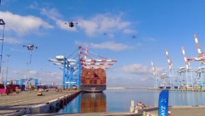 Ashdod, Israel: Ashdod Port Company has completed a landmark proof-of-concept for an autonomous drone ecosystem operating inside a live maritime environment, marking a major step toward the integration of unmanned systems within critical infrastructure. The pilot was conducted under the Port’s Maritime Technology Hub, Blue Ocean CVC, and brought together multiple technology partners to demonstrate real-time autonomous flight management, AI-driven analytics, and airspace control capabilities. The ecosystem integrates technologies from Airwayz, Sentrycs (acquired by Ondas Holdings Inc.), FlightOps, Propeller Drones, and Dynamic Infrastructure. Together, the companies tested a multi-layered operational framework capable of supporting security, safety, maintenance, and logistics missions inside one of Israel’s busiest ports. The project reflects a broader global shift toward UTM-enabled smart ports and builds on experience deployed at the Port of Rotterdam. Central to the pilot is Airwayz’s Autonomous Tactical Airspace Command & Control System (ATACCS), a dynamic UTM and C2 platform designed to autonomously authorize drone flights, allocate mission priorities, designate safe corridors, and detect unauthorized aerial activity. By linking airspace management with sea and land operations, the Port gains a unified operational picture intended to improve safety and decision-making across all departments Shaul Schneider, Chairman of Ashdod Port, said the initiative positions the port “at the forefront of innovation in Israel and worldwide,” noting that drones now serve as an added protective layer for a strategic national facility that must remain continuously operational. He highlighted Rotterdam’s similar model as a template for Ashdod’s modernization efforts. Nissan Levy, CEO of Ashdod Port, said autonomous drones enhance not replace human workforces, adding that the Port continues to seek technologies that raise efficiency and reinforce security. Airwayz CEO Eyal Zor described the system as an “autonomous control tower” that gives port operators full command of the skies, including mission approvals and real-time detection of unauthorized drones. He said the pilot showcases what a “smart and connected port” looks like when sea, land, and air operations are digitally linked. Roi Avrahami, Head of the Maritime Technology HUB (Blue Ocean CVC), said the ability to manage the port’s airspace adds a critical layer of safety by preventing conflicts between drones, ships, and infrastructure while maintaining complete situational awareness. He called the pilot an important step toward building safer, smarter, and more efficient ports with direct economic value. Ashdod Port is now evaluating plans to scale autonomous drone operations across its facilities and its international Innovation Embassies network.
