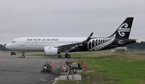 Auckland, New Zealand: An Airbus A320‑Neo operated by Air New Zealand (Flight NZ249) experienced an uncommanded engine shutdown mid‑flight last year, due to a defective fire‑switch, the Transport Accident Investigation Commission (TAIC) confirmed in its interim report released on 4 December 2025. The incident occurred on 1 December 2024, when the aircraft was en route from Wellington to Sydney. Approximately 40 minutes after takeoff, the No. 2 engine unexpectedly shut down following activation of the overhead fire‑switch despite no pilot input. The crew declared a mayday and safely diverted to Auckland Airport, with all 154 passengers and crew unharmed. TAIC’s report identifies internal damage to the fire‑switch mechanism as the primary cause. A retaining pin inside the switch had bent, reducing the latching security and allowing vibration or normal operation to trigger the switch inadvertently. Inspections revealed that the panel surrounding the switch also showed signs of deformation, further contributing to the uncommanded activation. “The fire‑switch is designed to be manually operated only in case of an actual engine fire,” TAIC noted. “Its activation without pilot input posed a significant safety risk.” The commission also highlighted that the same fire‑panel design is used across the global A320 fleet indicating that other aircraft could potentially be affected. The switch manufacturer had issued service bulletins in late 2024 recommending inspection of previously repaired panels, but those checks focused on visually detectable external damage. Following the ANZ incident, Airbus expanded its guidance to inspect all affected fire‑panels for any signs of deformation within 1,000 flight cycles. The European Union Aviation Safety Agency (EASA) has since issued an Airworthiness Directive mandating such inspections and, where necessary, replacement of defective panels. Air New Zealand reportedly removed suspect panels from its fleet in early December 2024. On 28 November 2025, Airbus triggered another major safety action ordering a global recall of approximately 6,000 A320‑family aircraft, following a serious mid‑air flight‑control issue linked to corruption of flight‑control data under intense solar radiation. In a statement, Airbus described the recall as “precautionary,” urging all operators worldwide to apply an immediate software rollback (or, where required, hardware modifications) before affected aircraft are flown again. This recall reportedly the largest in Airbus’s 55‑year history affects over half of the global A320 fleet and has already prompted airlines across the U.S., Europe, Asia and beyond to ground jets for urgent software updates.