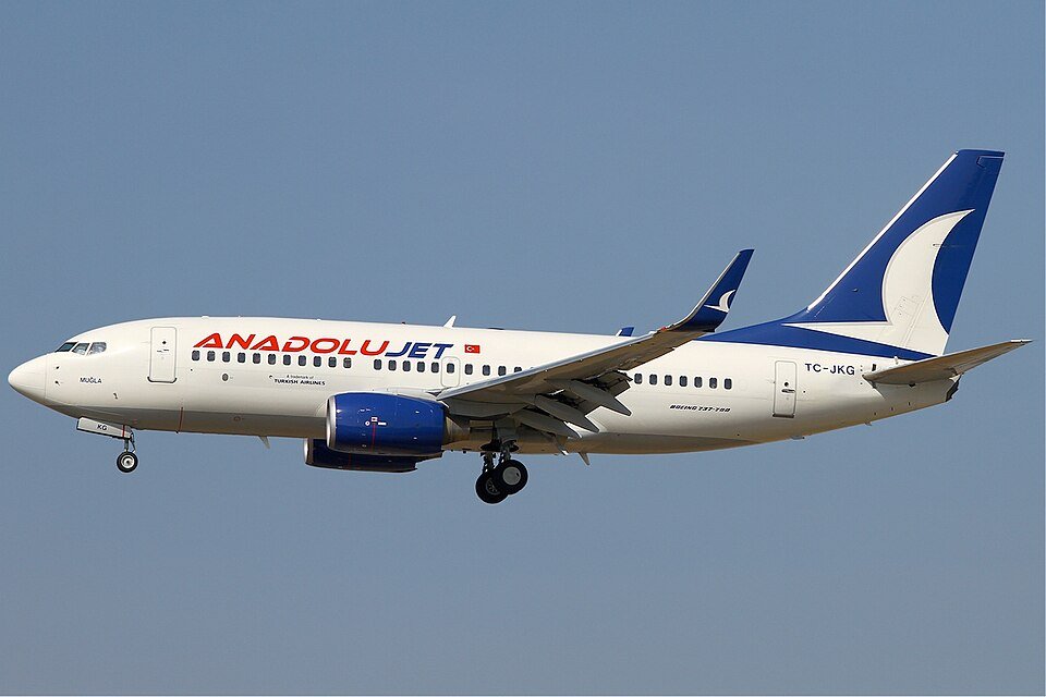 Istanbul, Turkey: A scheduled flight from Pristina to Istanbul ended in a runway excursion late on December 7 as a Anadolujet (AJet) Boeing 737-800 veered off the newly-opened runway at Sabiha Gökçen International Airport (SAW). The incident has forced closure of runway 06R/24L and triggered widespread flight delays and cancellations across one of Turkey’s busiest air hubs. Flight VF102 registration TC-JZN touched down on runway 24L just before 18:00 local time. According to Initial reports, the aircraft slowed but, while attempting a high-speed turnoff via taxiway A6 roughly 1,850 metres down the runway, failed to make the turn. The plane skidded off the paved surface onto soft ground adjacent to the runway, coming to a halt within the runway protected area. Despite the dramatic nature of the event, all passengers and crew on board were evacuated safely using external stairs and emergency slides were not deployed. There have been no reports of injuries. According to the airline and official statements from the embassy of Kosovo in Turkey, the aircraft’s deviation was not due to a mechanical failure or pilot error, but was triggered by wet and soft terrain following heavy rainfall in the area. Investigators have reportedly launched a probe to verify whether runway surface conditions played a decisive role. The incident forced an immediate closure of runway 06R/24L to allow for safe removal of the aircraft and inspection of the runway and taxiway infrastructure. Aviation authorities recorded flight delays. Flights operated by several major carriers including Turkish Airlines, as well as regional and international airlines were among those severely disrupted. For many passengers, plans for onward travel or hotel reservations in Istanbul and other destinations have been upended. Airport management crews have commenced full inspection of runway and taxiway surfaces, drainage systems, and runway safety features before reopening. Meanwhile, regulatory bodies have signaled that a broader review of weather-related landing protocols and runway maintenance procedures may follow.