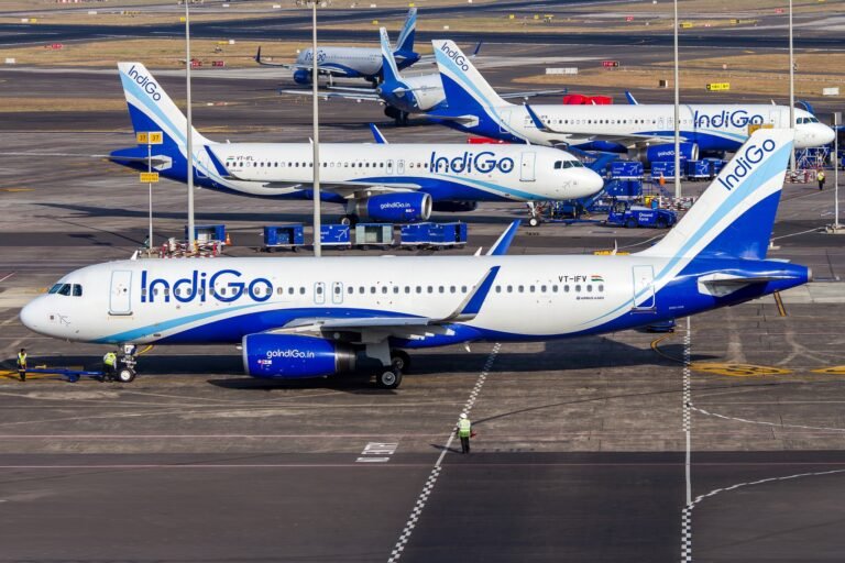 New Delhi, India: India’s largest airline, IndiGo, faced severe operational disruption on Thursday as flight cancellations mounted for a fourth consecutive day, with media reports estimating that cumulative cancellations during the multi-day disruption crossed the 550 flight mark nationwide. The impact was most visible at major airports including Delhi, Mumbai, Ahmedabad and Hyderabad, where nearly 200 flights were cancelled during the day, according to airport-level data. Long queues, missed connections and delayed rebookings were reported across terminals as the airline struggled to stabilise operations. IndiGo issued a public apology for the disruption and said it was working closely with airport authorities and regulators to restore normal schedules and minimise passenger inconvenience. The airline has been grappling with mounting operational stress over the past several days, driven largely by crew availability constraints and scheduling challenges following the implementation of stricter pilot duty and rest norms. Officials said the cascading effect of earlier cancellations further worsened aircraft and crew rotations across the network. Airport-wise data showed that Mumbai alone accounted for 86 cancellations, Bengaluru saw 73, and Delhi recorded over 30 cancellations, highlighting the scale of network-wide disruption at India’s busiest aviation hubs. The multi-day turmoil has left thousands of passengers stranded, with severe delays, missed connections, and cascading operational failures across the carrier’s domestic network. The flight cancellations followed a dramatic collapse in punctuality earlier in the week. On Wednesday, December 3, IndiGo’s on-time performance (OTP) plunged to just 19.7%, its lowest level in years. This marked a steep fall from 35% recorded a day earlier, indicating a rapid deterioration in schedule reliability. With fewer than one in five flights operating on time, IndiGo, once regarded as India’s most punctual airline, saw its reputation for schedule discipline severely eroded within 48 hours. For Thursday, December 4, sustained cancellations, rolling delays and aircraft rotation failures across multiple cities throughout the day indicated that punctuality remained under acute pressure. The crisis has been triggered primarily by an acute shortage of available pilots following the implementation of stricter crew duty and rest regulations. IndiGo underestimated the number of additional pilots required to sustain its high-frequency schedule under the new regulatory framework. As a result, the airline was left with little buffer once the stricter rest rules became enforceable. Once the first wave of cancellations began, the crisis escalated rapidly through cascading operational failures, including aircraft misplacement, delayed crew handovers, disrupted maintenance windows, and congestion at high-density airports. These knock-on effects compounded recovery efforts and caused rolling delays across multiple flight banks through the day. The underlying trigger for the disruption lies in the revised Flight Duty Time Limitation (FDTL) norms introduced by the DGCA, aimed at strengthening aviation safety by reducing fatigue-related risks for pilots. The second and most stringent phase of these rules came into force on November 1, 2025. Under the revised framework, pilots are mandated to receive 48 consecutive hours of weekly rest, face tighter limits on consecutive night duties, and are subject to caps on night landings and duty extensions. While the industry had advance notice of the regulatory changes, IndiGo’s internal staffing preparedness appears to have fallen short. Officials said the airline had operated with a very thin standby crew margin even before the new norms were enforced, leaving it vulnerable to large-scale disruption once pilot availability dropped. With passenger inconvenience mounting and network stability deteriorating, the DGCA has now stepped in to closely supervise IndiGo’s recovery plan. The regulator has directed the airline to submit a detailed mitigation strategy covering crew hiring, training schedules and revised rostering practices. DGCA is planning to grant IndiGo a temporary, conditional waiver from certain pilot rest provisions to arrest further operational collapse. The proposed relief is expected to be short-term and tightly monitored, with compliance milestones linked to crew augmentation and scheduling corrections. The regulator has made it clear that safety standards will not be permanently diluted and that any relaxation will be transitional. IndiGo has informed authorities that it expects phased stabilisation of its network by February 10, 2026, subject to successful induction of additional crew and progressive restoration of flight rotations. The disruption at IndiGo which operates over 2,000 flights daily and carries more than half of India’s domestic air passengers has sent ripples through the aviation sector. While the FDTL norms are widely seen as a necessary safety reform, the crisis has exposed the operational vulnerability of airlines that expand capacity faster than manpower buffers. For passengers, uncertainty is likely to continue in the near term. Aviation officials have advised travellers to monitor flight status closely and exercise refund and rebooking rights in the event of cancellations as IndiGo works to stabilise its schedule.