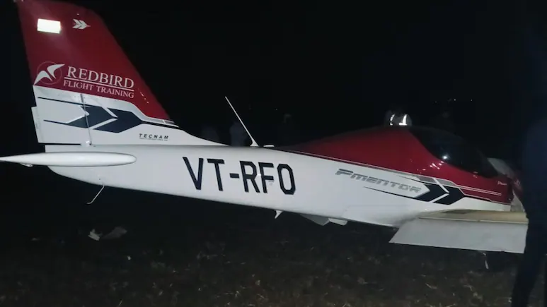 Seoni, India: A training aircraft belonging to Redbird Flight Training Academy crashed on Monday evening after its wing struck a 33 kV high-voltage power line near Sukatra village, in the Kurai police-station area of Seoni district. According to police, the incident occurred around 6:25–6:30 pm, roughly 2 km from the Suktara airstrip, as the aircraft was preparing to land. Eyewitness accounts describe sparks and a loud explosion as the plane’s wing contacted the line, after which the aircraft plunged into a nearby field. Authorities identified those on board as the instructor pilot Ajit Anthony and trainee pilot Ashok Chawda. Both sustained injuries and were taken to a private hospital in Barapathar. Officials say they are “out of danger.” Local police and power-company staff, aided by villagers, rescued the two pilots from the wreckage soon after the crash. A preliminary probe indicates that the aircraft may have suffered a “technical snag,” possibly an engine malfunction, causing it to lose power as it descended. The wing then struck the overhead power line of the Badalpar Substation, triggering the crash. The impact caused the 33 kV line to snap, immediately tripping the electricity supply. Roughly 80–90 villages around the substations reportedly experienced a blackout, and repair crews have been deployed to restore power to the affected areas. The district police have launched an official investigation to ascertain the precise cause of the crash. It remains uncertain whether pilot error, mechanical failure, or a combination of factors led to the collision. Final determination will await the outcome of the inquiry. So far, there have been no fatalities. Residents near the Suktara airstrip, however, expressed deep concern, noting that this was not the first incident involving a training aircraft in the area. Earlier in May 2025, a training aircraft operated by Redbird Aviation Pvt. Ltd. overturned during landing at the Suktara airstrip in Seoni district, Madhya Pradesh. The flight was being conducted solo by a trainee pilot. Initial reports attribute the incident to a faulty landing. Fortunately, the trainee escaped without injury and there was no fire. Months later on August 9, 2025 again a trainer aircraft of Redbird Flight Training Centre crash-landed near Baramati Airport in Pune district. During a routine training sortie at around 8 a.m., the trainee pilot realised one of the aircraft’s tyres was damaged. Upon touchdown, the front wheel detached and the aircraft veered off the taxiway, crossing to the far side of the airfield. Despite the abrupt landing and loss of the wheel, the pilot escaped unhurt.