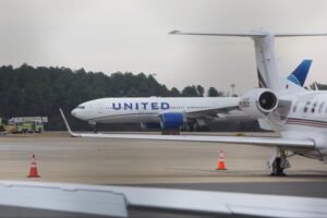Dulles, United States: A United Airlines Boeing 777 bound for Tokyo made an emergency return to Washington Dulles International Airport (IAD) on Saturday, December 13, after experiencing an engine malfunction shortly after takeoff, officials confirmed. United Flight 803, operating a Boeing 777-200ER with 275 passengers and 15 crew members on board, departed Dulles around midday for Tokyo’s Haneda Airport when one of its engines lost power. The Federal Aviation Administration (FAA) and airline spokespersons said the aircraft returned safely to the airport and landed without injury to any person on board. According to the FAA, the flight encountered a power loss in one engine shortly after departure. Visual footage shared on social media and confirmed by officials showed smoke near an airport runway after a part of the engine’s cowling separated and fell to the ground, igniting a patch of dry brush outside the runway perimeter. Fire crews on the ground quickly extinguished the blaze. Airport fire and rescue units inspected the aircraft after it returned, and operations at the affected runway were briefly paused before normal service resumed. United Airlines stated it would place passengers on a replacement aircraft later on Saturday to continue the scheduled flight to Tokyo. U.S. Transportation Secretary Sean Duffy confirmed that all passengers and crew disembarked safely and praised the crew’s conduct during the incident. The FAA has launched a formal investigation into the engine failure to determine the precise cause and ensure aviation safety protocols are upheld. An airport spokesperson reiterated that the emergency response was swift and effective, highlighting that the fire was contained quickly and no injuries were reported. United Airlines, in its statement, said it is cooperating fully with federal authorities to assess the mechanical issue. The airline also thanked emergency responders and airport personnel for their actions during the event.