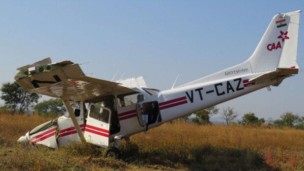 Dhana, India: A preliminary investigation report released by India’s Aircraft Accident Investigation Bureau (AAIB) has detailed how a Cessna 172S training aircraft operated by Chimes Aviation Pvt. Ltd. crashed during a go-around at Dhana Airstrip in Madhya Pradesh on December 10, 2025, leaving a 22-year-old trainee pilot with minor injuries and destroying the aircraft. The aircraft, registered VT-CAZ, was returning from a solo cross-country training flight when the accident occurred at 08:43 UTC (2:13 pm IST) while attempting to land on Runway 35. According to the AAIB, the trainee pilot made an initial approach but aborted the landing due to instability. During a second approach, the aircraft floated beyond the touchdown zone, prompting air traffic control to order another go-around. As the pilot advanced power, the aircraft pitched up abruptly, rolled left, and lost control, crashing onto the unpaved ground beside the runway. The pilot managed to unbuckle and escape from the wreckage. No fire broke out, but the aircraft sustained substantial damage, including shattered propeller blades, collapsed nose landing gear, broken windscreens, and bent wings. The trainee pilot held a valid Student Pilot License, had 74.5 flying hours, all on the Cessna 172, and had been medically cleared and well rested before the flight. A breath-analyser test conducted before departure was also normal. The aircraft, built in 2014, had a valid airworthiness certificate and had completed a 50-hour maintenance inspection just one day before the accident, on 9 December 2025, with no defects reported. Weather conditions were also favourable, with clear skies, 6 km visibility, and light winds, ruling out bad weather as a contributing factor. AAIB teams have secured the wreckage and recovered Garmin G1000 flight data, CCTV recordings, and engine and airframe components for detailed analysis. Fuel and oil samples are also being tested. Because the aircraft and key components were manufactured overseas, the US National Transportation Safety Board (NTSB) and Germany’s Federal Bureau of Aircraft Accident Investigation (BFU) have been notified and are assisting the Indian investigation. The AAIB stressed that the findings are preliminary and aimed only at preventing future accidents, not assigning blame. A final report will determine the root cause of the loss of control during the go-around.