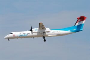 Nice, France: A Luxair regional aircraft was forced to perform an emergency landing at Nice Côte d’Azur Airport on Thursday, January 22, after the crew received a warning of a potential landing gear malfunction, the airline and aviation authorities confirmed. Flight LG8255, operated by a De Havilland Dash 8-400 turboprop registered LX-LQA, departed Luxembourg Findel Airport at approximately 13:17 local time en route to Nice with 74 passengers and crew onboard. According to initial reports, the flight crew received an “unsafe indication” for the right main landing gear during the approach to Nice. Following standard safety protocols, the aircraft aborted its first landing attempt and entered a holding pattern over the Mediterranean Sea to troubleshoot the issue. As a precautionary measure, the crew shut down the right-hand engine and prepared the cabin for an emergency landing, instructing passengers to assume the brace position. After approximately 75 minutes in the air, the aircraft returned to Nice and completed a safe landing on runway 04L, coming to a stop on the runway surface. The aircraft was unable to taxi under its own power and remained on the runway while emergency services attended. All 74 passengers and crew disembarked safely and were transported by bus to the terminal. Local airport authorities confirmed that no injuries were reported. Fire and rescue units had been pre-positioned on the runway as part of routine emergency response procedures. In response to the incident, air traffic at Nice was temporarily suspended, resulting in brief disruptions to scheduled arrivals and departures. Luxair CEO Gilles Feith described the situation as “an enormously stressful event” but praised the professionalism of the flight crew and passengers in managing the emergency. He attributed the issue to a faulty landing gear sensor, noting that after landing the indication returned to normal. “The sensor showed an unsafe indication, although the landing gear was later confirmed as locked,” Feith said in an interview. The airline has dispatched maintenance personnel and auditors to Nice to conduct a full technical investigation into the cause of the warning and ensure compliance with safety regulations.