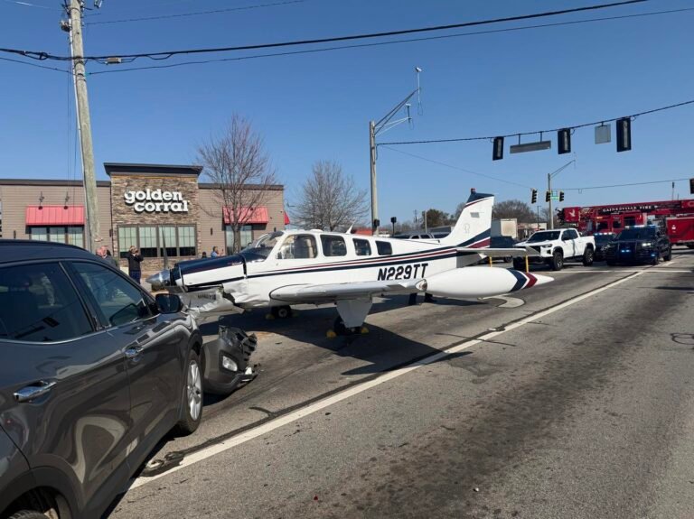 Plane Makes Emergency Landing After Engine Failure, Hits 3 Cars On Georgia Road SEO DES: The plane suffered engine power loss shortly after takeoff, colliding with three vehicles and causing minor injuries to two drivers. 2 onboard were safe. SOCIAL: A Hawker Beechcraft BE-36 made an emergency landing on a busy Gainesville roadway after suffering engine power loss shortly after takeoff, colliding with three vehicles and causing minor injuries to two drivers. The pilot and student pilot on board were not seriously hurt. The FAA and NTSB are investigating the incident, which occurred near Browns Bridge Road and Pearl Nix Parkway, as authorities continue clearing the aircraft and managing traffic disruptions. Videos of the landing showed the aircraft descending amid traffic and narrowly avoiding power lines. Air traffic control recordings captured the pilot issuing a mayday call moments before touchdown. Gainesville, United States: A small single-engine aircraft was forced to make an emergency landing on a busy Gainesville roadway Monday afternoon, colliding with three vehicles and causing minor injuries, authorities said. The Federal Aviation Administration (FAA) and the National Transportation Safety Board (NTSB) have opened investigations into the incident. The accident occurred at approximately 12:10 p.m. local time near the intersection of Browns Bridge Road and Pearl Nix Parkway, a major thoroughfare north of Atlanta. The 2010 Hawker Beechcraft BE-36, operating out of Lee Gilmer Memorial Airport, was en route to Cherokee County Regional Airport in Canton when the pilot reported engine trouble shortly after takeoff, according to FAA statements and local police. Police and witness accounts indicate the pilot attempted to return to the airport after detecting a loss of engine power but determined he could not reach the runway. Faced with limited options, the pilot executed an emergency landing on the roadway. The aircraft slid along the pavement and struck three vehicles in the intersection. Videos shared with media outlets capture the plane coming down on the road amid traffic, narrowly avoiding power lines and other hazards. A detached fuel tank from the aircraft was reported to have struck the rear of an SUV during the landing. Emergency responders quickly arrived at the scene. Police said two people, both drivers of separate vehicles involved in the crash, were injured and taken to a nearby hospital as a precaution. The two individuals on board the plane, identified by authorities as an experienced pilot and a student pilot, were not seriously injured and remained on-site to assist investigators. In air traffic control recordings reported by local media, the pilot can be heard declaring a mayday call shortly before touchdown and expressing concern for his safety, asking that messages be relayed to his family. Both the FAA and NTSB are investigating the incident to determine the cause of the engine failure and the sequence of events leading to the emergency landing. The intersection remains closed while crews wait for a specialized rollback truck capable of removing the aircraft from the roadway. Drivers are being warned to expect extended traffic delays in the area.