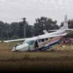 Preliminary Report Links Engine Oil Pressure Loss To Fatal India One Air Accident SEO DES: The crash killed one passenger and seriously injured three others, while the 48-year-old captain and 41-year-old first officer were also badly hurt SOCIAL: The Aircraft Accident Investigation Bureau (AAIB) has released its preliminary report on the January 10, 2026 crash of a Cessna Grand Caravan 208B EX operated by India One Air near Rourkela, Odisha. The aircraft experienced a drop in engine oil pressure about 30 nautical miles from destination, leading to engine shutdown and a Mayday call. While attempting a forced landing in an open field after abandoning a riverbed option, the aircraft struck a treetop and a high-tension power line before impact. One passenger died and three others were seriously injured, along with both pilots. Investigators found signs of oil leakage, and CVR/FDR data along with engine components are under detailed examination. The findings remain preliminary. Rourkela, India: India’s aviation accident regulator has released its preliminary findings into the crash of an India One Air Cessna Caravan aircraft near Rourkela last month, confirming that low engine oil pressure led to an emergency landing attempt that ended in a fatal accident. According to the Aircraft Accident Investigation Bureau (AAIB), the accident occurred on January 10, 2026, at 0747 UTC when a Cessna Grand Caravan 208B EX, registration VT-KSS, operating a scheduled Bhubaneswar–Rourkela service, was forced to land in an open field near Jalda village in Odisha. The aircraft, operated by India One Air, had departed from Biju Patnaik International Airport and was approaching Rourkela Airport when the crew observed a drop in engine oil pressure approximately 30 nautical miles from destination. The report states that the oil pressure showed a downward trend accompanied by reduced engine power. Following standard non-normal checklist procedures, the pilots shut down the engine and declared a Mayday with Rourkela Air Traffic Control, indicating their intention to attempt an emergency landing at the nearest suitable site. Investigators said the crew initially considered landing on a dry riverbed but abandoned the attempt due to insufficient altitude. They then selected an alternate open field that appeared free of major obstacles. However, during final approach, the aircraft struck a treetop and a high-tension power cable before impacting the ground. The impact caused substantial structural damage. The nose landing gear separated, the main landing gear deformed, and the forward fuselage suffered fragmentation. Investigators found oil stains along the fuselage belly extending toward the tail. No post-crash fire or smoke was observed. The accident resulted in the death of one passenger. Three other passengers sustained serious injuries. Both the pilot-in-command, aged 48, and the first officer, aged 41, also suffered serious injuries. The crew held valid commercial pilot licences, medical certificates, and were cleared by pre-flight breath analyser tests. Weather conditions at Rourkela at the time were reported as wind 060 degrees at 2 knots, visibility 7 km, no significant cloud, and QNH 1017 hPa. The Cockpit Voice Recorder (CVR) and Flight Data Recorder (FDR) data have been downloaded and are under analysis. The engine has been secured for detailed examination. The AAIB has appointed accredited representatives from the U.S. National Transportation Safety Board and the Transportation Safety Board of Canada to assist in the investigation. The bureau reiterated that the purpose of the investigation is the prevention of future accidents and not to apportion blame or liability. The findings remain preliminary and subject to change pending further technical analysis.
