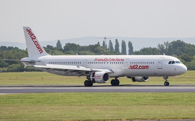 Jet2 Flight Declares Emergency Over UK After Pilot Becomes Incapacitated Mid-Air SEO DES: During approach, ATC was alerted after a pilot fell ill, emergency services were deployed and the remaining crew landed the aircraft safely at Manchester SOCIAL: A Jet2 Airbus A321 operating Flight LS980 from Lanzarote to Manchester declared a mid-air emergency during its final approach after one pilot became medically incapacitated. The crew activated Squawk 7700, prompting ATC to provide priority landing clearance and deploy emergency services. The remaining pilot landed the aircraft safely at Manchester. The affected pilot received medical attention. No passengers or crew were injured, and standard aviation safety protocols were followed throughout. Image: Transport Pixels (Flickr) Video: Jet 2 Manchester, United Kingdom: A Jet2 passenger aircraft declared a mid-air emergency during its approach to Manchester Airport on Tuesday evening after one of the pilots became incapacitated due to a medical issue, aviation and airline sources have confirmed. The aircraft, Flight LS980, an Airbus A321 bound from Lanzarote, Canary Islands to Manchester, transmitted a Squawk 7700 general emergency code, the international radio transponder signal indicating a critical in-flight emergency approximately 25 minutes before its scheduled landing. Flight data and reports indicate the Airbus A321 departed Lanzarote at about 15:45 GMT and initially progressed normally until the final stage of descent toward Manchester Airport. It was during this approach phase that the cockpit crew informed Air Traffic Control (ATC) that one pilot was unable to continue due to a sudden medical problem. In response, ATC provided priority handling and clearance for landing, while emergency services including fire, rescue and medical teams were placed on standby at the airport. Despite the sudden loss of one pilot, the remaining flight crew maintained control and continued the descent. The aircraft touched down safely on Runway 05L at Manchester Airport at approximately 20:14 GMT. Once on the ground, the incapacitated pilot was met by waiting medical personnel and taken for further assessment. There have been no reported injuries among passengers or cabin crew, and disembarkation occurred in a routine and orderly manner, according to airline and airport representatives. A Jet2 spokesperson told GB News the carrier had requested a priority landing after one of the pilots “felt unwell,” adding: “The aircraft landed safely and customers disembarked as normal.” Commercial jetliners such as the Airbus A321 typically operate with a captain and first officer. In the event one pilot becomes incapacitated, industry training and procedures direct the remaining qualified pilot to assume full control of the aircraft. Such protocols, regularly practiced in simulators, are designed to maintain safety during critical phases such as approach and landing. The use of Squawk 7700 ensures ATC and emergency services are rapidly made aware of in-flight emergencies so they can provide priority routing and ground support. Manchester Airport, one of Jet2’s principal UK hubs, confirmed that emergency equipment and teams were ready at the runway in anticipation of the flight’s arrival, reflecting standard safety protocol for declared emergencies.