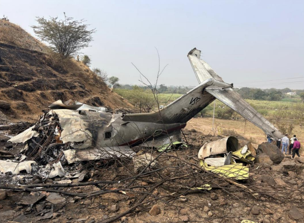 Baramati, India: The Aircraft Accident Investigation Bureau (AAIB) has released its preliminary report into the accident involving a Learjet 45XR aircraft, registration VT-SSK, which crash-landed at Baramati on 28 January 2026, resulting in five fatalities including the Hon’ble Deputy Chief Minister of Maharashtra. IMPORTANT NOTE: As per the AAIB, this report contains preliminary factual information subject to change. In accordance with ICAO Annex 13, the sole objective of this investigation is the prevention of future accidents and not the apportioning of blame or liability. No final conclusions should be drawn from this document at this stage. The aircraft, operated by M/s VSR Ventures Pvt. Ltd., was conducting a non-scheduled passenger flight from Chhatrapati Shivaji Maharaj International Airport (Mumbai) to Baramati. The accident occurred at approximately 0316 UTC (0846 IST) during the landing phase on Runway 11 at the uncontrolled Baramati airfield. Aircraft and Crew The aircraft was a Learjet 45XR (Serial No. 417), manufactured in 2010 and powered by Honeywell TFE 731-20BR-1B engines. It held a valid Certificate of Airworthiness and Airworthiness Review Certificate at the time of the accident. The aircraft had accumulated 4,915:48 total airframe hours. On board were two flight crew members, one cabin attendant and two passengers. All five occupants sustained fatal injuries. The Pilot-in-Command, aged 61, held an Airline Transport Pilot Licence (ATPL) and had 18,855 total flying hours, including 2,815 hours on type. The First Officer, aged 25, held a Commercial Pilot Licence (CPL) and had 2,490 total flying hours, including 2,243 hours on type. Both pilots were current and medically valid. Pre-flight breath analyser tests conducted prior to departure were reported as negative. Flight and Approach The flight departed Mumbai after filing a flight plan to Baramati, with Pune and Mumbai listed as alternates. The aircraft took off from Runway 27 at Mumbai and climbed to FL190 before descending toward Baramati. Baramati is an uncontrolled airfield managed by M/s Maharashtra Airport Development Company Limited (MADC). The aerodrome permits only Visual Flight Rules (VFR) operations and does not have navigational aids other than windsocks. The runway orientation is 11/29, with displaced thresholds of 1,400 ft for Runway 11 and 500 ft for Runway 29. According to the report, the airfield does not have a Meteorological (MET) facility. Weather information is relayed using instruments installed in a temporary tower operated by one of the flying training organisations based at the airfield. During the initial approach, the crew requested visibility information and were advised it was 3 kilometres. The report notes that the visibility required for VFR flight is 5 kilometres. The aircraft continued the approach but initiated a go-around. On the second approach to Runway 11, the aircraft reported the field in sight and was cleared to land. Winds were reported as calm. Shortly thereafter, the aircraft was heard transmitting “Oh S**T Oh S**T” before impacting terrain to the left of Runway 11, abeam the threshold. CCTV footage from a nearby village reportedly showed the aircraft banking to the right before striking trees and impacting ground approximately 50 metres left of the runway edge. The aircraft was engulfed in fire and was destroyed. Aerodrome Observations During on-site inspection, investigators observed faded runway markings and the presence of loose gravel on the runway surface. The last runway re-carpeting was conducted in March 2016. The report also states that the aerodrome does not have an in-house Aircraft Rescue and Fire Fighting (ARFF) unit. Firefighting and ambulance services are provided by the Baramati Municipal Corporation upon request. Additionally, the aerodrome does not have a boundary wall, and fencing was reported to be inadequate. Weather Context METAR data from nearby controlled airports showed reduced visibility conditions on the morning of the accident. Pune reported visibility as low as 2,000 metres between 0240 and 0300 UTC, while Mumbai reported 2,500 metres visibility during the period. Satellite imagery from INSAT-3DR indicated no significant clouding over Pune but suggested the presence of shallow fog patches in the vicinity of Baramati. Flight Recorders Both the Solid-State Flight Data Recorder (SSFDR) and Solid-State Cockpit Voice Recorder (SSCVR) were recovered from the tail section. Although both units sustained thermal damage, raw data from the SSFDR has been successfully downloaded at the AAIB laboratory in New Delhi and is under analysis. Due to thermal damage and manufacturer considerations, assistance has been sought from the United States to recover data from the SSCVR, in accordance with ICAO Annex 13 provisions. The National Transportation Safety Board (NTSB), USA, has appointed an Accredited Representative and technical advisers to assist in the investigation. Interim Safety Recommendations Based on interim findings, the AAIB has issued safety recommendations to the Directorate General of Civil Aviation (DGCA). These include directing operators conducting VFR flights to uncontrolled airfields to strictly adhere to standard operating procedures, and ensuring flying operations are permitted only when prevailing meteorological conditions meet regulatory criteria. The AAIB has also recommended that DGCA issue directions to stakeholders responsible for managing uncontrolled airfields to maintain required safety standards, enhance landing aids and basic MET facilities, and examine the feasibility of licensing such aerodromes for regulated operations.