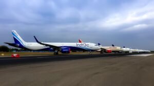 Delhi, India: India’s domestic aviation sector sustained its expansion in 2025, with scheduled domestic carriers ferrying 1,669.46 lakh (166.946 million) passengers for the calendar year, marking a 3.48 per cent increase over the 1,613.31 lakh passengers recorded in 2024, according to the latest official traffic data. The Directorate General of Civil Aviation (DGCA) monthly report shows the growth was powered by consistent passenger demand, despite significant operational challenges experienced during the final month of the year. For the full year ending December 2025, domestic travel grew to 166.946 million passengers, compared with 161.331 million in 2024. This uptick reflects sustained recovery in both leisure and business travel markets. However, December 2025 bucked the annual growth trend, with traffic falling 4.14 per cent month‑on‑month. Approximately 14.30 million passengers flew on domestic sectors in December a significant reduction from previous months. Industry sources and airport operators have tied the December slump chiefly to weeks of widespread schedule disruptions at one of India’s largest carriers, which led to cancellations and repositioning of flights across several high‑density routes. IndiGo, India’s largest domestic airline by market share, saw its proportion of the domestic market decline sharply in December 2025. DGCA data shows the carrier’s share dropped to 59.6 per cent, down from 63.6 per cent in November. This was one of the lowest monthly market share figures for the airline in recent years, reflecting the operational challenges it faced. In contrast, several competitors capitalised on displaced traffic flows during this period. The Air India Group’s market share rose to 29.6 per cent, while Akasa Air increased to 5.2 per cent, and SpiceJet to 4.3 per cent in December 2025. The DGCA also reported that delays and service irregularities in December generated heightened consumer issues, with more than 29,000 complaints logged with airlines for that month. An estimated 8.34 lakh passengers were affected by flight delays, while carriers collectively spent more than ₹4.5 crore on passenger facilitation. In addition, thousands of passengers were denied boarding due to operational adjustments, prompting additional compensation outlays approaching ₹2.08 crore. Following the disruptions, IndiGo has stated that it has taken steps to bolster operational resilience. The airline increased its crew buffer to approximately 3 per cent in early February 2026, alongside raising the pilot‑to‑aircraft ratio, after operating with minimal buffers in December. The DGCA and airline industry stakeholders have signalled that measures to ensure stability including compliance with updated rest norms for crew and enhanced scheduling strategies are central to mitigating future volatility.