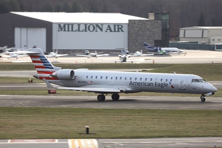 American Eagle Flight Returns To Raleigh-Durham Airport After Smoke Alert Mid-Air SEO DES: Passengers evacuated with no injuries, American Airlines cited a “reported odor”; aircraft grounded for inspection, cause still under investigation SOCIAL: An American Eagle CRJ-900 flight returned to Raleigh-Durham International Airport shortly after takeoff due to reported smoke and a burning odor in the cabin. The aircraft landed safely within 23 minutes, with emergency services on standby. Passengers were evacuated and no injuries were reported. American Airlines said the diversion was due to a “reported odor,” and the aircraft was taken out of service for inspection, with the exact cause yet to be determined. Image: Quintin Soloviev (Wikimedia) Video: American Airlines Morrisville, United States: An American Eagle regional flight was forced to return to Raleigh-Durham International Airport shortly after takeoff on Monday night after pilots reported smoke and a burning odor inside the aircraft cabin, prompting an emergency response. American Eagle Flight 5201, operated by a Bombardier CRJ-900, departed Raleigh-Durham International Airport (RDU) at approximately 8:13 p.m. en route to Philadelphia. Within minutes of departure, the flight crew detected what was described as smoke accompanied by a burning smell inside the cabin, triggering standard emergency procedures. Following the detection, pilots elected to discontinue the climb and remain in the vicinity of the airport while preparing for a safe return. Flight tracking and local reports indicate the aircraft maneuvered over northern Wake County, executing turns over Falls Lake and later looping near Jordan Lake to align for landing. The aircraft landed safely at RDU approximately 23 minutes after departure under emergency conditions. Emergency services, including fire crews and EMS units, were positioned on standby as the aircraft touched down. Visuals from the airport showed the aircraft surrounded by emergency vehicles shortly after landing. Passengers were evacuated onto the tarmac and transported to the terminal by buses. No injuries were reported among passengers or crew. American Airlines confirmed that the flight returned to RDU due to a “reported odor” onboard, a term commonly used in aviation when the exact source of smoke or fumes has not yet been identified. The aircraft was subsequently taken out of service for a detailed inspection by maintenance teams. “All passengers made it safely to the terminal, and we are working to assist them with their travel plans,” the airline said, apologizing for the disruption and commending the crew’s handling of the situation. As of now, no confirmed cause of the smoke or odor has been officially released.