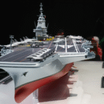 Macron Unveils ‘France Libre’ New Next-Gen Nuclear Aircraft Carrier Plan For France SEO DES: Designed as Europe’s largest warship, France Libre will be about 310m long with a displacement of 75,000–80,000 tonnes, boosting major naval capability SOCIAL: French President Emmanuel Macron has named France’s next-generation nuclear aircraft carrier “France Libre”, replacing the Charles de Gaulle by 2038 and boosting strategic autonomy. The €10 billion project, formerly PANG, will be Europe’s largest warship, powered by nuclear reactors and capable of operating Rafale jets, Hawkeye aircraft, and drones. Positioned as key to France’s defence strategy, the carrier boosts nuclear deterrence and expands global deployment capability amid rising geopolitical tensions. Paris, France: French President Emmanuel Macron has officially named France’s next-generation nuclear-powered aircraft carrier “France Libre”, marking a significant step in the country’s long-term naval modernization strategy and its push for strategic autonomy. Macron announced the name during a visit to the shipyard at Indret in western France, where early work on the vessel’s nuclear reactors has already begun. The name “France Libre” meaning “Free France”pays tribute to the World War II resistance movement led by Charles de Gaulle, symbolizing national resilience and independence. The new aircraft carrier will replace the aging Charles de Gaulle, currently France’s only aircraft carrier and the only nuclear-powered carrier in service outside the United States. Commissioned in 2001, the vessel is expected to retire by 2038, when the new carrier becomes operational following sea trials planned around 2036. The France Libre programme, previously known as the Porte-avions de nouvelle génération (PANG), forms the backbone of France’s future naval aviation capability. Designed to be the largest warship ever built in Europe, the France Libre will measure approximately 310 meters in length and displace around 75,000 to 80,000 tonnes. The carrier will be powered by two nuclear reactors, enabling extended deployment without frequent refuelling and reinforcing France’s nuclear deterrence posture. It is expected to carry: Around 30 Rafale fighter jets Airborne early warning aircraft such as E-2D Hawkeye Helicopters and next-generation unmanned aerial systems (UAVs/UCAVs) The vessel will also incorporate advanced launch and recovery systems, including electromagnetic catapults (EMALS), aligning it with next-generation carrier technologies. The programme is estimated to cost €10–10.2 billion ($11–12 billion), making it one of Europe’s most ambitious defence projects. Reactor component manufacturing began in 2025 Full-scale construction is expected around 2030–2031 Sea trials are projected for 2035–2036 Entry into service is targeted for 2038 The project involves major French defence and industrial players, including Naval Group, Chantiers de l’Atlantique, and TechnicAtome. Macron framed the programme as essential in an evolving global security environment, describing oceans as “new arenas of contemporary conflict.” France remains the only nuclear-armed nation in the European Union, and the new carrier will reinforce its ability to deploy nuclear-capable aircraft at sea. The announcement also comes amid heightened military activity, with France recently deploying the Charles de Gaulle and additional naval assets to the Mediterranean and Middle East in response to regional tensions. Paris views the programme as central to: Maintaining continuous carrier availability Strengthening NATO contributions while enhancing European defence autonomy Expanding global power projection, particularly in strategic maritime regions Beyond its military role, the name “France Libre” carries strong political symbolism. Macron described it as a commitment to national strength and independence, invoking the legacy of resistance and sovereignty. “In this name lives the memory to remain free, we must be powerful,” he said, linking historical identity with future defence ambitions. As Europe navigates an increasingly complex security landscape, the project signals France’s intent to combine historical legacy, nuclear capability, and advanced technology into a single strategic platform.