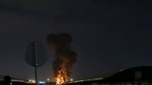 Drone Strike Triggers Fire At Kuwait International Airport Amid Escalating Gulf Crisis SEO DES: Kuwait has reported multiple recent attacks, including strikes on radar systems & fuel tanks, reflecting rising threats to critical aviation infrastructure SOCIAL: A drone strike hit a fuel tank at Kuwait International Airport in Kuwait City, Kuwait, triggering a fire that was quickly contained with no casualties and limited damage. The incident is part of a series of recent drone and missile attacks linked to escalating Iran-U.S.-Israel tensions, with authorities continuing investigations as regional security risks intensify. Kuwait has reported multiple similar attacks in recent weeks, including strikes on radar systems and fuel facilities, reflecting growing threats to critical aviation infrastructure. The situation reflects a broader regional escalation, with Gulf nations facing increased aerial threats and rising concerns over aviation safety and fuel supply stability. Kuwait City, Kuwait: A drone strike targeting fuel storage infrastructure at Kuwait International Airport triggered a fire on Wednesday, marking the latest escalation in a widening regional conflict linked to the ongoing Iran-U.S.-Israel tensions. According to Kuwait’s Civil Aviation Authority, the attack struck a fuel tank at the airport, causing a blaze that was swiftly contained by emergency response teams. Authorities confirmed that no casualties or injuries were reported, and initial assessments indicated that the damage was limited to infrastructure. Emergency protocols were immediately activated, with firefighting units responding to the scene and bringing the situation under control within a short period. Officials have not yet disclosed the origin of the drone or the group responsible, and investigations remain ongoing. Agency spokesman Abdullah Al-Rajhi said the impact was “limited,” confirming that firefighters were continuing operations to fully extinguish the blaze. Preliminary assessments indicated that the attack caused only material damage. The incident is not isolated. Kuwait has faced repeated drone and missile attacks in recent weeks, as regional tensions intensified following coordinated military actions involving Iran, the United States, and Israel. Wednesday’s strike is the latest in a string of attacks targeting Kuwait’s main airport since the conflict intensified on February 28. Earlier incidents include a March 14 drone strike on radar systems and a March 8 attack that damaged fuel storage facilities. A separate strike on a passenger terminal had left several people with minor injuries. Kuwait’s military has repeatedly reported “waves of hostile drones” entering its airspace, with air defense systems actively intercepting incoming threats. The attack comes amid a broader escalation in the Middle East, where Iran has launched drone and missile strikes targeting the U.S.-linked assets and allied countries across the Gulf, including Kuwait, Bahrain, and Jordan. Kuwait, which hosts U.S. military installations, has increasingly found itself exposed to retaliatory strikes as the conflict expands beyond its initial theaters. In recent weeks, the country has also reported casualties among security personnel and damage to infrastructure linked to ongoing aerial attacks, reflecting the persistent threat environment. Globally, the conflict has begun to impact aviation operations and fuel supply chains, with rising jet fuel prices and early signs of disruptions to flight networks in parts of Asia and beyond. Kuwaiti authorities continue to assess the full extent of the damage and are working to determine the source and intent behind the attack. No group has officially claimed responsibility so far.