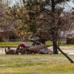 Small Plane Crash In Albuquerque Leaves One Dead, Second Victim In Critical Condition SEO DES: State police identified the deceased as 63‑year‑old Deborah Rhinesmith of Wichita, Kansas; the injured remains unnamed. FAA and NTSB are investigating SOCIAL: A small Columbia 400 aircraft crashed at Los Altos Golf Course in Albuquerque, New Mexico, while attempting an emergency landing Friday morning. One person, 63-year-old Deborah Rhinesmith of Wichita, Kansas, died, and a second passenger remains in critical condition. First responders extricated both occupants and transported them to University of New Mexico Hospital. The plane had departed from Wichita Dwight D. Eisenhower National Airport en route to Arizona. The FAA and NTSB are investigating the crash; the cause of the emergency landing is not yet known. Albuquerque, United States: A small aircraft attempting an emergency landing at Los Altos Golf Course in Albuquerque crashed Friday morning, killing one person and leaving another in critical condition, authorities confirmed. The incident occurred shortly before 11:40 a.m. local time when the single‑engine aircraft went down on the golf course while attempting what officials described as an emergency landing. First responders from Albuquerque Fire Rescue and New Mexico State Police arrived on scene and found two occupants trapped inside the severely damaged plane. Fire crews reported the aircraft was not engulfed in flames but sustained significant structural damage upon impact. Both occupants were extricated and transported by ambulance to the University of New Mexico Hospital. One patient was pronounced dead at the hospital, while the second remains in critical condition; no further medical updates have been released. State police later identified the deceased as 63‑year‑old Deborah Rhinesmith of Wichita, Kansas. Officials have not yet publicly named the critically injured person. Flight records and Federal Aviation Administration (FAA) data indicate the plane was registered in Wichita and had departed from Wichita Dwight D. Eisenhower National Airport earlier Friday morning on a flight bound for Arizona. The cause of the emergency landing attempt has not been determined. The National Transportation Safety Board (NTSB) and the FAA have both confirmed they are investigating the crash. Preliminary reports show the aircraft was a Columbia 400 model, a single‑engine airplane commonly used for private and training flights. Local authorities are continuing their investigation. Anyone with additional information or who may have witnessed the plane before the crash has been asked to contact New Mexico State Police. Further updates will be issued as official findings are released.