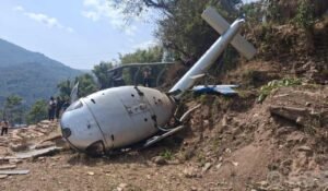 Nepal Helicopter Crash In Khotang During Landing, One Passenger Critically Injured SEO DES: The helicopter operated by Air Dynasty Heli Service carried five passengers and the body of a deceased individual for final rites when the incident occurred SOCIAL: A helicopter operated by Air Dynasty Heli Service crashed while landing in Balabesi, Khotang district of eastern Nepal, leaving one passenger injured while all others, including the pilot, were safe. The aircraft had departed from Kathmandu carrying five passengers and the body of a deceased person when it lost balance during touchdown on farmland around 11:51 a.m. local time and overturned. It sustained damage after rolling sideways on landing. Authorities confirmed no fatalities. The injured elderly passenger suffered leg and eye injuries and was airlifted to Kathmandu for treatment. Emergency responders and another helicopter from the same operator carried out rescue operations quickly. Preliminary reports suggest strong winds, dust reducing visibility, and loss of control during landing may have contributed, though the Civil Aviation Authority of Nepal has launched an investigation. Khotang, Nepal: A helicopter operated by Air Dynasty Heli Service Pvt. Ltd. crashed while attempting to land in Balabesi area of Khotang district in eastern Nepal on Wednesday, leaving one passenger critically injured while all other occupants survived with minor injuries, according to civil aviation officials and local authorities. The helicopter operated by pilot Sabin Thapa, had departed from Kathmandu, was carrying five passengers along with the body of a deceased individual being transported for final rites. The aircraft was attempting a landing on farmland in Balabesi around 11:51 a.m. local time when it suddenly lost balance and overturned upon touchdown. Officials confirmed that the helicopter hit the ground during its final approach and rolled sideways before coming to rest, sustaining significant damage. “No human casualties have been recorded. More details are due”, Rekha Kandel, chief district officer of Khotang district told ANI. The critically injured passenger, identified in local reports as an elderly man, 65, a resident of Lalitpur named Kaji Bahadur, suffered injuries to his leg and eye and was immediately airlifted to Kathmandu for advanced medical treatment using another helicopter dispatched from the same operator. The helicopter was carrying the lifeless body of Manalakshmi Rai, 77, a resident of Balabensi who passed away a month ago in the UK. The body as reported was being brought by her relatives for cremation. Also on board the helicopter were the deceased’s husband, Dakmani Rai, 83, son Balkumar Rai, 53, daughter Laxmi Rai, 47 and 40-year-old Samala Rai. Officials confirmed that all passengers along with the pilot Sabin Thapa were safely rescued from the crash site. Preliminary assessments suggest the crash may have been triggered by: Strong winds at the landing site Dust clouds reducing visibility during touchdown Loss of control during final landing phase Authorities have not confirmed the final cause, and a formal investigation has been launched by Nepal’s aviation regulator. Footage circulating online shows the helicopter descending normally before suddenly tipping on its side during landing. The aircraft then overturned on the uneven terrain, with locals rushing immediately to rescue passengers. Local residents, along with emergency responders, quickly reached the site and helped evacuate all occupants. Another Air Dynasty helicopter was deployed to transport the injured passenger and pilot to Kathmandu for treatment. Officials confirmed that emergency response operations were completed within a short time after the incident. The helicopter involved belongs to Air Dynasty Heli Service Pvt. Ltd., one of Nepal’s private helicopter operators frequently used for medical, rescue, and charter flights in mountainous regions. "One passenger on board the helicopter has been injured. The pilot and other passengers are safe. Another helicopter with registration number 9N-ANA has also been dispatched for the rescue of the injured passenger," the helicopter company announced in a statement. Helicopter operations, especially in eastern hill districts like Khotang, are often exposed to sudden wind shifts and dust conditions during landing.