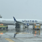 United Jet Hits De-Icing Truck at Denver Airport; Driver Injured, Passengers Safe SEO DES: The collision occurred as heavy snowfall moved across the Denver area, forcing airlines to conduct extensive de-icing operations across the airport SOCIAL: A United Airlines Boeing 737-800 preparing to depart Denver International Airport struck a de-icing truck on March 6, forcing passengers to disembark and triggering an investigation by the Federal Aviation Administration. The aircraft, operating as Flight 605 to Nashville International Airport, carried 122 passengers and six crew. No one onboard was injured, but the truck driver was hospitalized. Passengers were bused back to the terminal and later rebooked as the aircraft underwent inspection. Denver, United States: A United Airlines aircraft preparing for departure at Denver International Airport struck a de-icing truck during ground operations on March 6, forcing passengers to disembark and prompting a federal investigation. According to the Federal Aviation Administration, United Airlines Flight 605, a Boeing 737-800 scheduled to fly from Denver to Nashville International Airport, made contact with the ground vehicle at around 8:30 a.m. local time while exiting a de-icing pad. The incident occurred in an area of the airfield not managed by air traffic control. In a statement, a spokesperson for United Airlines explained: “A de-icing truck made contact with a United aircraft in Denver on Friday morning, leading to an employee of the de-icing contractor being transported to the hospital.” The statement added, “Customers deplaned via air stairs and were bused to the terminal, and we arranged for a different aircraft to take customers to their destination.” The aircraft was carrying 122 passengers and six crew members at the time. No injuries were reported among those on board, but the driver of the de-icing truck, an employee of a contracted ground-service provider, was transported to a hospital after the collision. Authorities have not disclosed the extent of the worker’s injuries. Following the incident, passengers exited the aircraft using mobile stairs and were transported by bus back to the terminal. United Airlines said it would arrange an alternative aircraft to continue the flight to Nashville while the damaged jet undergoes inspection. The collision occurred as heavy snowfall moved across the Denver area, forcing airlines to conduct extensive de-icing operations across the airport. Weather disruptions contributed to widespread delays throughout the day, with hundreds of flights affected at the busy hub. The FAA has opened an investigation to determine how the aircraft came into contact with the ground vehicle during the de-icing procedure.