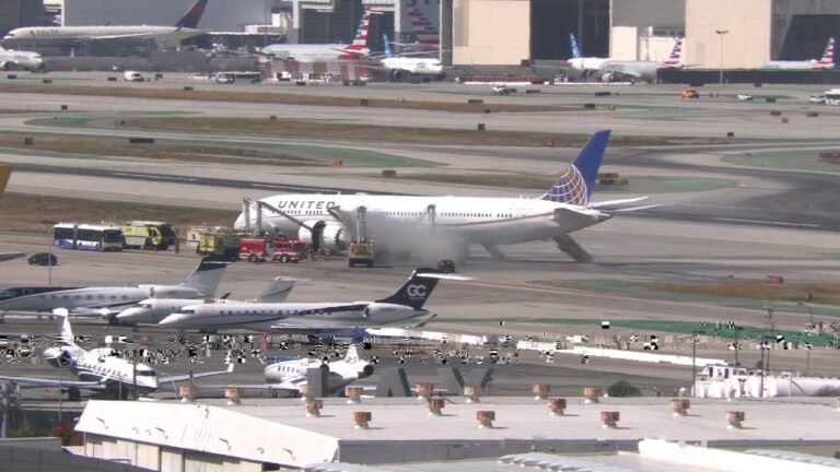 United Airlines Boeing 787 Makes Emergency Return To LAX After Engine Fire Report SEO DES: Emergency crews responded as smoke was reported from one engine and passengers evacuated using slides and mobile stairs, No serious injuries were reported SOCIAL: An United Airlines Boeing 787-9 operating Flight UA2127 from Los Angeles to Newark returned to Los Angeles International Airport shortly after takeoff on Monday after the crew reported an engine fire. The aircraft, carrying 256 passengers and 12 crew members, declared an emergency and landed safely at 11:19 a.m. Emergency crews responded as smoke was reported from one engine, and passengers evacuated using slides and mobile stairs. No serious injuries were reported. The FAA briefly issued a ground stop at LAX and has launched an investigation into the incident. Image: ABC7 Video: Fox News Los Angeles, United States: An United Airlines Boeing 787-9 Dreamliner bound for New Jersey was forced to make an emergency return to Los Angeles International Airport (LAX) on Monday after its crew reported an engine fire shortly after takeoff, authorities and airline officials said. United Flight UA2127 departed LAX at approximately 10:43 a.m. local time for Newark Liberty International Airport (EWR) with 256 passengers and 12 crew members aboard. Moments after departure, the flight crew reported trouble with the aircraft’s left-hand engine and declared an emergency with air traffic control. The Boeing 787-9, a twin-engine wide-body long-haul aircraft, began its return to LAX shortly before 11:00 a.m. and landed safely at 11:19 a.m. local time, according to Federal Aviation Administration (FAA) advisories and flight tracking data. As the aircraft approached its runway, emergency responders on the ground were alerted to reports of smoke or fire from one engine. Local fire crews, including the Los Angeles Fire Department, responded to contain the situation after landing. Video posted on social media showed plumes of dark smoke emanating from the affected engine on final approach. Once on the ground, the cabin crew initiated an evacuation. Passengers exited via inflatable emergency slides and mobile stairs onto a taxiway off the runway, then were transported by buses to the terminal. Emergency services remained on site to monitor and extinguish any remaining flame or heat from the engine. United Airlines confirmed in a statement that there were no serious injuries reported among passengers and crew. The FAA temporarily halted inbound flights to LAX for about 30 to 90 minutes following the incident, issuing a ground stop as emergency crews assisted on the scene. The ground stop was later lifted, though some incoming flights faced delays of up to 30 minutes. The FAA has opened an investigation to determine the precise cause of the engine malfunction and the subsequent fire reports. At this time, no official cause has been confirmed by the airline or regulators. Federal authorities typically examine flight data, engine health parameters, and cockpit voice recordings in such incidents.