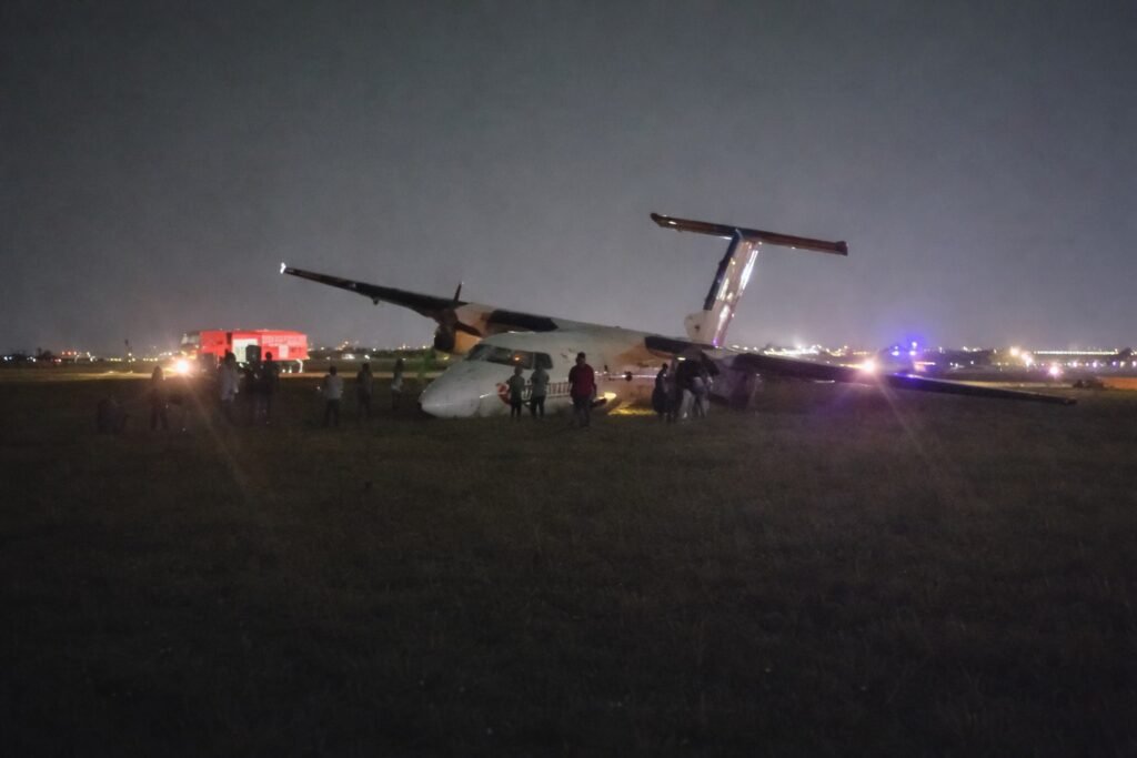 Safarilink Aircraft Veers Off Runway At Wilson Airport, All 39 Onboard Escape Unharmed SEO DES: Wet runway & low visibility caused loss of directional control during rollout, Aircraft sustained nose, landing gear & propeller damage; AAID probe underway SOCIAL: A Safarilink Aviation aircraft veered off the runway while landing at Wilson Airport on Friday night, carrying 39 people, including 34 passengers and five crew. All occupants escaped unharmed. The Flight 090 aircraft from Kisumu to Nairobi reportedly skidded off a wet runway and came to rest on a grassy area. The Kenya Airports Authority confirmed there were no injuries. The aircraft sustained damage to its nose, landing gear, and propeller. Adverse weather conditions are suspected as a contributing factor, while Kenya’s Aircraft Accident Investigation Department has launched a probe. Image: FL360aero Video: FL360aero Nairobi, Kenya: A Safarilink Aviation passenger aircraft veered off the runway while landing at Wilson Airport on Friday night, triggering fresh scrutiny over safety, infrastructure, and emergency preparedness at one of East Africa’s busiest domestic aviation hubs. The aircraft, operating as Flight 090 from Kisumu to Nairobi, was carrying 39 people onboard, including 34 passengers and five crew members, when the incident occurred at approximately 8:55 PM (2055 hrs). All occupants escaped without injury, authorities confirmed. According to airline and airport statements, the aircraft, a De Havilland DHC-8-100 (Dash 8) operated by ALS Limited on behalf of Safarilink skidded off the runway during landing and came to a stop on a grassy section near a runway intersection. The Kenya Airports Authority (KAA) confirmed the runway excursion in an official statement, “An aircraft with thirty nine passengers on board… veered off the runway, all passengers and crew are safe, with no injuries reported.” The aircraft sustained visible damage, including to its nose section, landing gear, and propeller, though no fire or fatalities occurred. Initial details point to adverse runway conditions as a contributing factor. The runway was reported to be wet due to rain, with reduced visibility at the time of landing The aircraft lost directional control during rollout, leading to the excursion Passengers described a sudden and forceful deviation from the runway, turning what should have been a routine landing into a high-risk situation. Among those onboard was Vihiga Senator Godfrey Osotsi, who described the incident as a “crash-landing” and credited the flight crew for preventing a catastrophe. “I commend the pilot… for controlling the aircraft and steering it off the runway, causing it to stall an action that averted what could have been a catastrophic fire,” he said. The manoeuvre likely prevented the aircraft from continuing at speed along the runway, reducing the risk of fire or structural breakup. Osotsi, speaking as a survivor, said all onboard escaped safely but highlighted the severity of the situation: “I came out safely from an aircraft accident… I was among the 39 passengers on board.” Passengers experienced a sudden loss of control during landing, followed by an abrupt stop after the aircraft exited the runway. No serious injuries were reported, and all occupants were safely evacuated. Despite the safe outcome, the incident has sparked serious concerns over airport safety systems. Osotsi alleged critical failures in emergency response, stating: No ambulance was present No immediate rescue or emergency team responded Passengers were initially left without assistance “There was no ambulance on site and no emergency response team came to our aid,” he said. Kenya’s Aircraft Accident Investigation Department (AAID) has launched a formal probe into the incident.