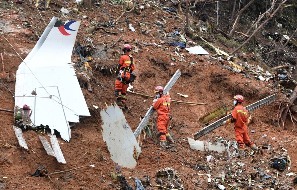 Wuzhou, China: The Boeing 737-800 aircraft, operating a routine domestic service from Kunming to Guangzhou on March 21, 2022, was carrying 132 people, including 123 passengers and nine crew members. About an hour into the flight, while cruising at altitude, the aircraft suddenly entered a steep and rapid descent before plunging almost vertically into a mountainous, forested area in Guangxi. All 132 occupants were killed, and no survivors were found, marking China’s deadliest air crash. China’s aviation regulator, the Civil Aviation Administration of China, launched an investigation immediately after the crash, dispatching emergency teams to the remote impact site. Due to the aircraft’s U.S. manufacture, the investigation also involved international participants, including the National Transportation Safety Board, Boeing, and the Federal Aviation Administration, who provided technical assistance. A major breakthrough in the early phase of the investigation came with the recovery of both flight recorders. The cockpit voice recorder was located on March 23, 2022, followed by the flight data recorder, which was retrieved from deep within the crash debris days later. Both devices were severely damaged due to the high-impact crash and required detailed forensic analysis, including data extraction overseas. Preliminary examination of the data indicated that the aircraft descended rapidly from around 29,000 feet, briefly stabilized, and then entered a final near-vertical dive. Air traffic controllers attempted to contact the pilots multiple times during the descent, but no distress call was made and no response was received from the cockpit. In its preliminary report released in April 2022, the CAAC ruled out several common causes of aviation accidents. Investigators found no evidence of mechanical failure, adverse weather conditions, or dangerous cargo. The aircraft was deemed airworthy and properly maintained, while the flight crew were found to be qualified, adequately rested, and medically fit. Follow-up updates issued in 2023 and 2024 reiterated these findings, stating that no abnormalities had been identified in the aircraft systems, flight operations, or air traffic control procedures. Despite these findings, investigators have not been able to establish a definitive cause of the crash. A report published in 2022 by The Wall Street Journal, citing U.S. officials familiar with black box analysis, suggested that the aircraft may have been intentionally put into a dive from the cockpit. However, Chinese authorities have not confirmed this interpretation and have cautioned against speculation, warning that unverified conclusions could mislead the public and interfere with the investigation. Under international aviation standards set by the International Civil Aviation Organization, accident investigations are expected to produce an initial report within 30 days and a final report within one year wherever possible. In the case of MU5735, a preliminary report was issued within the required timeframe, but no final report has been released even after four years. The last official update from Chinese authorities came in March 2024, with no substantive developments disclosed since then. The prolonged delay has drawn attention from global aviation bodies, including the International Air Transport Association, which has emphasized the importance of timely accident reports in improving aviation safety worldwide. As of 2026, the investigation into Flight MU5735 remains officially ongoing. No confirmed cause has been identified, and no comprehensive final report has been made public.
