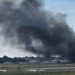 Adelaide, Australia: A light aircraft crash at Parafield Airport on Wednesday afternoon has left two people dead and at least 11 others injured after the plane slammed into a hangar and triggered a major fire, authorities confirmed. The aircraft, identified as a Diamond DA42 twin-engine training plane, was carrying two occupants, a pilot and one passenger both of whom were killed in the crash. Officials have yet to release their identities. No other passengers were onboard, confirming the total number of people in the aircraft at the time was two. The incident occurred at approximately 2:10 pm local time as the aircraft was attempting to land. During the approach, the plane reportedly lost control and crashed into a hangar, believed to be Hangar 54, causing a powerful impact that ignited aviation fuel and set off a large blaze. Thick black smoke was seen billowing into the sky as emergency services rushed to the scene. The crash resulted in significant injuries on the ground. At least 11 people inside the hangar were injured, with emergency officials confirming that one person suffered life-threatening burns and two others sustained serious injuries, while several others were treated for minor injuries and smoke inhalation. The injured were transported to nearby hospitals, including Royal Adelaide Hospital and Lyell McEwin Hospital. Firefighters and emergency responders acted swiftly to contain the blaze, deploying multiple crews to bring the fire under control despite challenging conditions. Authorities evacuated nearby areas and issued public safety alerts due to heavy smoke. The airport was temporarily closed to all air traffic as emergency operations and safety inspections were carried out. The Australian Transport Safety Bureau (ATSB) has launched a formal investigation into the accident. Investigators will examine the wreckage, flight conditions and any potential technical or operational factors that may have contributed to the crash. Preliminary witnesses suggest the aircraft may have experienced difficulty shortly before impact, though officials have not confirmed a cause. Parafield Airport is located about 18 kilometres north of Adelaide, is one of Australia’s busiest general aviation and pilot training hubs, frequently used by flight schools.
