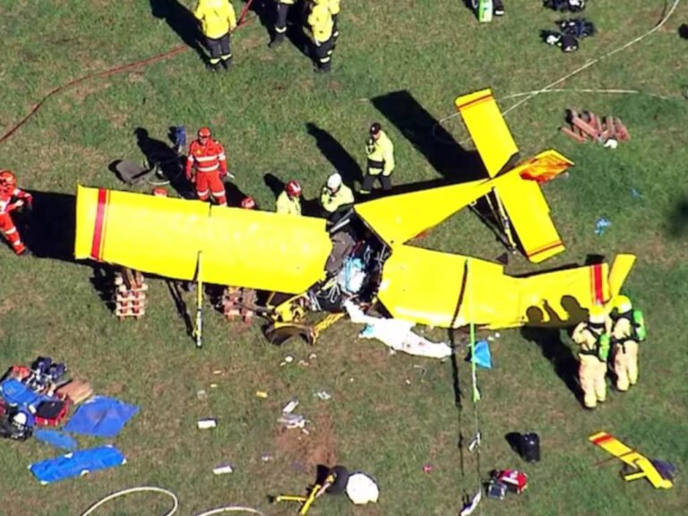 Berrima, Australia: A pilot suffered critical injuries after a light aircraft crashed into a paddock in the Southern Highlands region of New South Wales on Thursday morning, triggering a large-scale emergency response and an ongoing investigation into the cause of the accident. Emergency services were called to Medway Road in Berrima at approximately 7:45–7:50 am on April 16, 2026, following reports that a small aircraft had gone down in an open field. Responding crews, including police, Fire and Rescue NSW, NSW Ambulance, the State Emergency Service (SES), and the Rural Fire Service, arrived to find a severely damaged recreational plane with its sole occupant trapped inside the wreckage. The aircraft has been identified as a Hornet STOL ultralight, a small fixed-wing aluminium recreational plane. Initial information indicates the aircraft came down under unknown circumstances, with no immediate indication of the cause. The pilot, a man believed to be in his 50s, was trapped inside the wreckage “for some time” before firefighters were able to extricate him in a complex rescue operation. Paramedics treated the man at the scene for significant face and leg injuries before he was airlifted by helicopter to Liverpool Hospital. Authorities confirmed he remains in critical condition. The crash prompted a substantial multi-agency emergency deployment. Fire and Rescue NSW dispatched at least five units, including specialised HAZMAT crews, who worked to isolate a minor fuel leak and mitigate the risk of fire at the crash site. NSW Ambulance deployed multiple crews along with two helicopters, while police and other emergency services secured the area and assisted in the rescue effort. Aerial footage from the scene showed the aircraft described as a yellow plane with red markings lying heavily damaged in a paddock as emergency personnel worked around the wreckage. New South Wales Police have launched an investigation into the incident, and aviation authorities have been notified. The Australian Transport Safety Bureau (ATSB) confirmed it is aware of the crash, although it typically investigates recreational aircraft incidents only in exceptional circumstances. At this stage, the circumstances leading up to the crash remain unclear, and no further details have been released regarding the flight’s origin, intended destination, or weather conditions at the time of the incident.