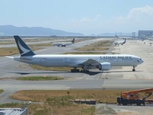 Osaka, Japan: A long-haul flight operated by Cathay Pacific diverted to Japan on April 7 after the crew detected an abnormal engine indication while en route from Los Angeles to Hong Kong, triggering a precautionary emergency response. Flight CX883, operated by a Boeing 777-300ER, was carrying 370 passengers and crew when cockpit systems indicated a drop in engine oil levels during cruise over the Pacific Ocean. Such alerts are treated with high priority in commercial aviation due to their potential implications for engine performance and long-range flight safety. The flight crew initiated standard emergency protocols and diverted the aircraft to Kansai International Airport, one of the nearest suitable diversion airports capable of handling widebody operations. The aircraft landed safely at approximately 4:30 a.m. local time. No injuries were reported, and passengers disembarked normally. In a statement, Cathay Pacific said the diversion was conducted “in accordance with established safety procedures,” emphasizing that safety remains its top operational priority. The airline confirmed that the aircraft has been withdrawn from service pending a comprehensive technical inspection by engineering teams to determine the cause of the engine oil indication. The airline arranged alternative flights to Hong Kong, but the sudden influx of disrupted passengers placed pressure on ground handling resources at Kansai. The incident caused minor delays to another flight at Kansai International Airport due to the emergency landing. Cathay Pacific has initiated a technical investigation into the incident. Engineers will examine the affected engine system, review flight data, and determine whether the issue stemmed from a mechanical fault, sensor anomaly, or other contributing factors.