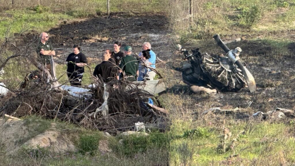Williston, United States: A fatal crash involving a vintage military training aircraft claimed two lives near Williston Regional Airport on Sunday afternoon, prompting a federal investigation into the circumstances surrounding the accident. According to local authorities and multiple reports, the incident occurred at approximately 3:30 PM on April 13, 2026, when a North American AT-6D Texan, a historic single-engine aircraft, went down a few miles from the airport in Levy County. The crash site was located near the intersection of Northeast 30th Street and 114th Avenue. Emergency responders, including Levy County Sheriff’s deputies and fire rescue teams, arrived quickly at the scene following reports from witnesses. Officials confirmed that both individuals onboard the aircraft were killed in the crash. Their identities have not yet been released. The aircraft involved, the AT-6 Texan, is a World War II-era trainer widely used by the U.S. military between the 1930s and 1950s. Such aircraft are typically privately owned today and maintained as part of the warbird and vintage aviation community. Preliminary information indicates that the aircraft may have been a restored example in civilian operation. Authorities secured the area shortly after the crash and advised the public to avoid the vicinity while recovery and investigative efforts were underway. No injuries on the ground or damage to nearby structures have been reported so far. The Federal Aviation Administration (FAA) and the National Transportation Safety Board (NTSB) have launched a joint investigation into the accident. Officials will examine multiple factors, including the aircraft’s maintenance history, pilot credentials, weather conditions at the time of the crash, and any available flight data or eyewitness accounts. As of now, the cause of the crash remains undetermined. Investigators are expected to release further details in the coming days as evidence is analyzed. In another incident on April 10, 2026, a small aircraft crashed in Okaloosa County, Florida, after experiencing a complete engine failure, leaving two people injured. According to the Okaloosa County Sheriff’s Office, the aircraft, identified as a two-seat Cub, went down near the Baker area shortly after takeoff from a local airstrip. The pilot reported that the engine failed completely at an altitude of about 200 feet while conducting a low flyover, causing the aircraft to descend and crash onto private property. The pilot was able to exit the aircraft and call emergency services, while the passenger was trapped and had to be extricated by rescue teams. Both occupants were conscious when responders arrived and were transported to hospital, one by ground and the other airlifted as a precaution. Authorities are investigating the incident
