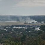 Adelaide, Australia: A fatal light aircraft crash at Parafield Airport on April 29 has left two people onboard dead and at least 11 individuals injured on the ground after the aircraft struck a hangar during a landing attempt and erupted into flames. The incident triggered a major emergency response, with authorities launching an investigation into the cause of the crash. Further details have emerged following the fatal light aircraft crash at Parafield Airport, with investigators and authorities providing new insights into the sequence of events, victims, and aircraft operation. The Australian Transport Safety Bureau (ATSB) confirmed the aircraft involved was a Diamond DA42 Twin Star conducting a training flight at the time of the accident. The flight was engaged in circuit training, a standard procedure involving repeated take-offs and landings. According to investigators, the aircraft had completed multiple circuits before the crash occurred during the approach phase. Authorities confirmed that two occupants were onboard a student pilot and a flight instructor and both were killed. Reports indicate the student pilot was a Japanese national, while the instructor was an Australian national, Police further confirmed the victims were men aged 24 and 29 respectively. Preliminary findings suggest that after turning onto final approach, the aircraft descended steeply and impacted terrain before colliding with a hangar, leading to a high-intensity fuel-fed fire. The aircraft was destroyed on impact. Data indicates no distress call was made prior to the crash, and investigators are now examining wreckage, flight path data, and operational factors. According to aviation database records from Aviation Safety Network, the aircraft was associated with Flight Training Adelaide (FTA), one of the major flight training organisations operating at Parafield Airport. In an official statement, Adelaide Airport Limited, which manages Parafield Airport, said emergency services responded immediately to the incident. The airport operator confirmed the crash involved a light aircraft impacting a hangar, resulting in fatalities and multiple injuries on the ground. The statement added that the airport was closed temporarily, emergency protocols were activated, and support was being provided to those affected. The airport authority also stated it is cooperating fully with investigators. Initial reports indicated that at least 11 people were injured in the crash; however, subsequent official updates clarified that 10 people were injured on the ground, including one with life-threatening burns, two with serious injuries, one with minor injuries, and six affected by smoke inhalation. The ATSB has deployed a team of specialists to the crash site to conduct a detailed examination, focusing on aircraft systems, engine performance, flight path, and human factors. Investigators will also analyse maintenance records and training procedures as part of the probe. A preliminary report is expected in the coming weeks, while a final report may take several months.