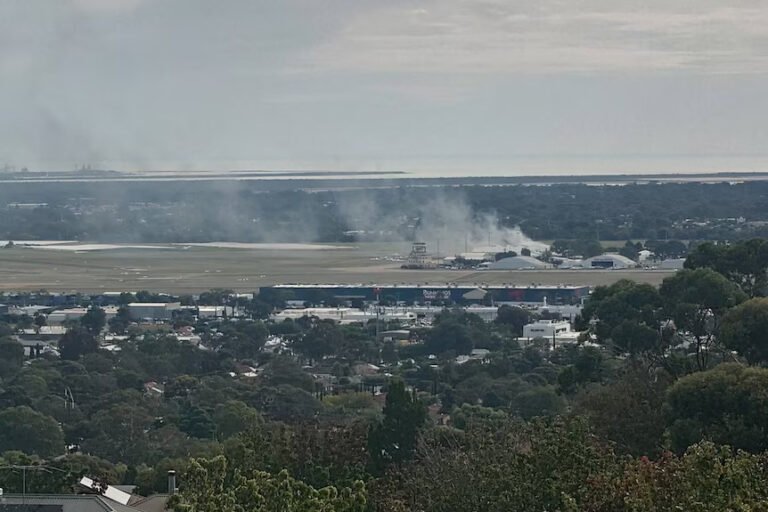 Adelaide, Australia: A fatal light aircraft crash at Parafield Airport on April 29 has left two people onboard dead and at least 11 individuals injured on the ground after the aircraft struck a hangar during a landing attempt and erupted into flames. The incident triggered a major emergency response, with authorities launching an investigation into the cause of the crash. Further details have emerged following the fatal light aircraft crash at Parafield Airport, with investigators and authorities providing new insights into the sequence of events, victims, and aircraft operation. The Australian Transport Safety Bureau (ATSB) confirmed the aircraft involved was a Diamond DA42 Twin Star conducting a training flight at the time of the accident. The flight was engaged in circuit training, a standard procedure involving repeated take-offs and landings. According to investigators, the aircraft had completed multiple circuits before the crash occurred during the approach phase. Authorities confirmed that two occupants were onboard a student pilot and a flight instructor and both were killed. Reports indicate the student pilot was a Japanese national, while the instructor was an Australian national, Police further confirmed the victims were men aged 24 and 29 respectively. Preliminary findings suggest that after turning onto final approach, the aircraft descended steeply and impacted terrain before colliding with a hangar, leading to a high-intensity fuel-fed fire. The aircraft was destroyed on impact. Data indicates no distress call was made prior to the crash, and investigators are now examining wreckage, flight path data, and operational factors. According to aviation database records from Aviation Safety Network, the aircraft was associated with Flight Training Adelaide (FTA), one of the major flight training organisations operating at Parafield Airport. In an official statement, Adelaide Airport Limited, which manages Parafield Airport, said emergency services responded immediately to the incident. The airport operator confirmed the crash involved a light aircraft impacting a hangar, resulting in fatalities and multiple injuries on the ground. The statement added that the airport was closed temporarily, emergency protocols were activated, and support was being provided to those affected. The airport authority also stated it is cooperating fully with investigators. Initial reports indicated that at least 11 people were injured in the crash; however, subsequent official updates clarified that 10 people were injured on the ground, including one with life-threatening burns, two with serious injuries, one with minor injuries, and six affected by smoke inhalation. The ATSB has deployed a team of specialists to the crash site to conduct a detailed examination, focusing on aircraft systems, engine performance, flight path, and human factors. Investigators will also analyse maintenance records and training procedures as part of the probe. A preliminary report is expected in the coming weeks, while a final report may take several months.