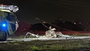 Corpus Christi, United States: A training flight ended in a serious accident Monday evening after a single-engine aircraft struck power lines and crashed just short of the runway at Corpus Christi International Airport, leaving two occupants critically injured. According to the Federal Aviation Administration (FAA), the incident occurred at approximately 7:25 p.m. local time during the aircraft’s approach phase. The aircraft, identified as a Piper PA-28, went down near Highway 44 frontage road, triggering an emergency response from multiple agencies. The aircraft was operated by Splendid Aviation, a flight training school. The company confirmed that the flight involved a certified instructor and a student pilot, both of whom sustained injuries in the crash. Emergency crews transported the victims to a nearby hospital before they were later transferred to Brooke Army Medical Center in San Antonio for advanced treatment. In a public statement, the flight school said the aircraft “came into contact with power lines while on approach”, adding that it is cooperating fully with investigators and refraining from speculation on the cause. First responders, including the Corpus Christi Fire Department, arrived shortly after receiving reports around 7:20 p.m. and found the aircraft down on the roadway and on fire. The crash site prompted a large-scale emergency response involving, Corpus Christi Police Department, Nueces County Sheriff’s Office, Annaville Fire Department and Airport authorities Damage to power lines contributed to hazardous conditions at the site, with local reports indicating power disruptions in the surrounding area. The National Transportation Safety Board (NTSB) will lead the investigation, with support from the FAA. Officials confirmed the aircraft crashed under unknown circumstances during the approach phase, and no preliminary cause has been established. Investigators are expected to examine, flight path and altitude during final approach, obstacle clearance and situational awareness, pilot training dynamics and instructor intervention and aircraft condition and operational factors. Authorities have emphasized that it is too early to determine the cause of the accident. The Piper PA-28, a widely used training aircraft, is a single-engine, light utility airplane commonly deployed in flight schools worldwide due to its reliability and training suitability.