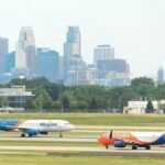 Las Vegas, United States: Allegiant Air has completed its $1.5 billion acquisition of Sun Country Airlines, creating one of the largest leisure-focused ultra-low-cost airline groups in the United States as consolidation continues across the American aviation sector. The merger, finalized following shareholder and regulatory approvals, combines two carriers known for serving price-sensitive leisure travelers and underserved routes across North America. The transaction marks a significant shift in the ultra-low-cost carrier market at a time when airlines are facing rising operating costs, changing travel demand patterns, and increasing competitive pressure. Under the agreement first announced earlier this year, Sun Country shareholders received a mix of cash and Allegiant stock, with Allegiant shareholders expected to hold approximately 67% of the combined company while Sun Country investors retain the remaining stake. The deal values Sun Country at approximately $1.5 billion, including debt. Executives from both airlines described the merger as a strategic move aimed at expanding network reach, improving operational efficiency, and diversifying revenue streams beyond traditional passenger services. The combined airline group will operate a fleet of nearly 195 aircraft and serve around 175 destinations through more than 650 routes across the United States, Mexico, Central America, and the Caribbean. Allegiant’s strong presence in smaller and underserved U.S. markets complements Sun Country’s established leisure network and charter operations centered around Minneapolis-St. Paul. One of the most significant aspects of the acquisition is Sun Country’s cargo and charter business, which provides Allegiant with additional non-passenger revenue opportunities. Sun Country currently operates dedicated cargo flights for Amazon and also conducts charter services for sports teams, military movements, and government operations. Despite the completion of the transaction, both airlines will continue operating separately during the initial integration phase. Company officials said the transition toward a unified operation is expected to take up to 18 months, including the eventual move toward a single FAA operating certificate. Allegiant’s Las Vegas headquarters will remain the primary corporate base, while Minneapolis is expected to continue serving as a major operational hub for the combined carrier. Passengers are not expected to experience immediate changes following the merger. Existing bookings, flight schedules, and loyalty programs will remain unchanged during the early stages of integration. Branding for both airlines will also continue temporarily while operational systems are gradually combined. The merger comes amid continued restructuring across the U.S. aviation industry, particularly within the ultra-low-cost segment. Rising fuel prices, labor expenses, aircraft delivery delays, and intense competition from larger network carriers have placed financial pressure on several budget airlines in recent years. Spirit Airlines shut down after 34 years following the collapse of a bailout deal and severe financial losses. The airline ceased operations on May 2, 2026, cancelling all flights and impacting thousands of passengers and employees. Rising costs, debt, failed merger attempts, and bankruptcy struggles led to the collapse of the U.S. budget carrier. Company executives stated that the merger is expected to generate substantial annual cost synergies over the coming years through combined purchasing power, operational efficiencies, and expanded route coordination.