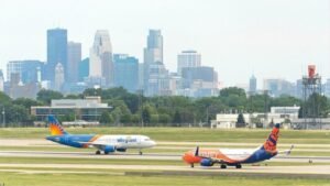 Las Vegas, United States: Allegiant Air has completed its $1.5 billion acquisition of Sun Country Airlines, creating one of the largest leisure-focused ultra-low-cost airline groups in the United States as consolidation continues across the American aviation sector. The merger, finalized following shareholder and regulatory approvals, combines two carriers known for serving price-sensitive leisure travelers and underserved routes across North America. The transaction marks a significant shift in the ultra-low-cost carrier market at a time when airlines are facing rising operating costs, changing travel demand patterns, and increasing competitive pressure. Under the agreement first announced earlier this year, Sun Country shareholders received a mix of cash and Allegiant stock, with Allegiant shareholders expected to hold approximately 67% of the combined company while Sun Country investors retain the remaining stake. The deal values Sun Country at approximately $1.5 billion, including debt. Executives from both airlines described the merger as a strategic move aimed at expanding network reach, improving operational efficiency, and diversifying revenue streams beyond traditional passenger services. The combined airline group will operate a fleet of nearly 195 aircraft and serve around 175 destinations through more than 650 routes across the United States, Mexico, Central America, and the Caribbean. Allegiant’s strong presence in smaller and underserved U.S. markets complements Sun Country’s established leisure network and charter operations centered around Minneapolis-St. Paul. One of the most significant aspects of the acquisition is Sun Country’s cargo and charter business, which provides Allegiant with additional non-passenger revenue opportunities. Sun Country currently operates dedicated cargo flights for Amazon and also conducts charter services for sports teams, military movements, and government operations. Despite the completion of the transaction, both airlines will continue operating separately during the initial integration phase. Company officials said the transition toward a unified operation is expected to take up to 18 months, including the eventual move toward a single FAA operating certificate. Allegiant’s Las Vegas headquarters will remain the primary corporate base, while Minneapolis is expected to continue serving as a major operational hub for the combined carrier. Passengers are not expected to experience immediate changes following the merger. Existing bookings, flight schedules, and loyalty programs will remain unchanged during the early stages of integration. Branding for both airlines will also continue temporarily while operational systems are gradually combined. The merger comes amid continued restructuring across the U.S. aviation industry, particularly within the ultra-low-cost segment. Rising fuel prices, labor expenses, aircraft delivery delays, and intense competition from larger network carriers have placed financial pressure on several budget airlines in recent years. Spirit Airlines shut down after 34 years following the collapse of a bailout deal and severe financial losses. The airline ceased operations on May 2, 2026, cancelling all flights and impacting thousands of passengers and employees. Rising costs, debt, failed merger attempts, and bankruptcy struggles led to the collapse of the U.S. budget carrier. Company executives stated that the merger is expected to generate substantial annual cost synergies over the coming years through combined purchasing power, operational efficiencies, and expanded route coordination.