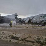 El Alto, Bolivia: Bolivian authorities have arrested the pilot and co-pilot of a Bolivian Air Force Lockheed C-130H Hercules following an official investigation that concluded the February 2026 crash near La Paz was preventable and largely linked to operational errors during landing. The aircraft crashed on February 27, 2026, while attempting to land at El Alto International Airport, after completing a domestic flight from Santa Cruz. During landing in adverse weather, the aircraft failed to decelerate on the runway, veered off the surface, breached the airport perimeter, and ploughed into a busy roadway, striking multiple vehicles before breaking apart in a densely populated area. The crash resulted in 24 fatalities and at least 43 injuries, with the majority of victims on the ground. Among the dead were civilians, including passengers in public transport vehicles hit by the aircraft. Several crew members were also injured, making it one of Bolivia’s deadliest aviation disasters in recent decades. Initial reports had indicated a lower death toll, but the number rose significantly as rescue teams recovered victims from the wreckage and surrounding impact zone. The situation on the ground quickly descended into chaos after it emerged that the aircraft was transporting a large consignment of newly printed banknotes for the Central Bank of Bolivia. The impact scattered currency across the crash site, drawing crowds of civilians who rushed to collect the money. Authorities deployed police and military units, including the use of tear gas, to secure the area and allow emergency responders to operate. Officials later declared the banknotes invalid, as they had not yet entered circulation, and subsequently destroyed recovered cash. A formal investigation by the Bolivian Air Force, the findings of which were released on April 30, 2026, identified a chain of operational failures rather than a single-point cause. Investigators determined that adverse weather conditions, including a wet runway and reduced braking efficiency, were contributing factors but not the primary cause. Instead, the report placed significant emphasis on pilot handling during the landing phase. According to the findings, the aircraft executed an improper landing sequence, touching down with the nose gear before the main landing gear, a critical procedural error that compromised braking effectiveness and aircraft stability. This technique reduced aerodynamic drag and delayed the full deployment of braking systems, significantly increasing stopping distance on an already wet runway. The report further highlighted inadequate coordination and communication with air traffic control, which may have affected situational awareness during the final approach and landing rollout. Investigators also pointed to failure to execute a go-around despite unstable landing conditions, a decision that could have prevented the accident altogether. Additionally, the probe noted that standard landing protocols and safety margins were not maintained, particularly given the weather conditions. The combination of these factors resulted in a runway excursion at high speed, leaving the crew unable to regain control before the aircraft exited the airfield boundary. Crucially, investigators concluded that the crash was preventable, stating that proper adherence to established landing procedures and timely decision-making would likely have avoided the accident. Based on these findings, Bolivian prosecutors issued arrest warrants for the pilot and co-pilot on April 30, with both taken into custody on May 1, 2026, following questioning. The two are currently being held in pre-trial detention and face charges of involuntary manslaughter, with authorities alleging that negligent handling of the aircraft and failure to follow standard operating procedures directly contributed to the loss of life.