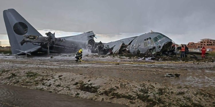 El Alto, Bolivia: Bolivian authorities have arrested the pilot and co-pilot of a Bolivian Air Force Lockheed C-130H Hercules following an official investigation that concluded the February 2026 crash near La Paz was preventable and largely linked to operational errors during landing. The aircraft crashed on February 27, 2026, while attempting to land at El Alto International Airport, after completing a domestic flight from Santa Cruz. During landing in adverse weather, the aircraft failed to decelerate on the runway, veered off the surface, breached the airport perimeter, and ploughed into a busy roadway, striking multiple vehicles before breaking apart in a densely populated area. The crash resulted in 24 fatalities and at least 43 injuries, with the majority of victims on the ground. Among the dead were civilians, including passengers in public transport vehicles hit by the aircraft. Several crew members were also injured, making it one of Bolivia’s deadliest aviation disasters in recent decades. Initial reports had indicated a lower death toll, but the number rose significantly as rescue teams recovered victims from the wreckage and surrounding impact zone. The situation on the ground quickly descended into chaos after it emerged that the aircraft was transporting a large consignment of newly printed banknotes for the Central Bank of Bolivia. The impact scattered currency across the crash site, drawing crowds of civilians who rushed to collect the money. Authorities deployed police and military units, including the use of tear gas, to secure the area and allow emergency responders to operate. Officials later declared the banknotes invalid, as they had not yet entered circulation, and subsequently destroyed recovered cash. A formal investigation by the Bolivian Air Force, the findings of which were released on April 30, 2026, identified a chain of operational failures rather than a single-point cause. Investigators determined that adverse weather conditions, including a wet runway and reduced braking efficiency, were contributing factors but not the primary cause. Instead, the report placed significant emphasis on pilot handling during the landing phase. According to the findings, the aircraft executed an improper landing sequence, touching down with the nose gear before the main landing gear, a critical procedural error that compromised braking effectiveness and aircraft stability. This technique reduced aerodynamic drag and delayed the full deployment of braking systems, significantly increasing stopping distance on an already wet runway. The report further highlighted inadequate coordination and communication with air traffic control, which may have affected situational awareness during the final approach and landing rollout. Investigators also pointed to failure to execute a go-around despite unstable landing conditions, a decision that could have prevented the accident altogether. Additionally, the probe noted that standard landing protocols and safety margins were not maintained, particularly given the weather conditions. The combination of these factors resulted in a runway excursion at high speed, leaving the crew unable to regain control before the aircraft exited the airfield boundary. Crucially, investigators concluded that the crash was preventable, stating that proper adherence to established landing procedures and timely decision-making would likely have avoided the accident. Based on these findings, Bolivian prosecutors issued arrest warrants for the pilot and co-pilot on April 30, with both taken into custody on May 1, 2026, following questioning. The two are currently being held in pre-trial detention and face charges of involuntary manslaughter, with authorities alleging that negligent handling of the aircraft and failure to follow standard operating procedures directly contributed to the loss of life.