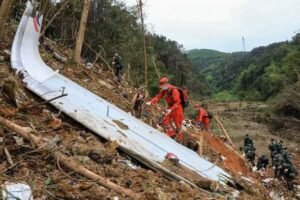 Wuzhou, China: The crash of China Eastern Airlines Flight 5735 crash continues to raise critical questions more than four years after the disaster, as newly surfaced U.S. investigative data points toward deliberate cockpit actions while Chinese authorities maintain silence, citing national security concerns. On March 21, 2022, a Boeing 737-800 operated by China Eastern Airlines plunged from cruising altitude into mountainous terrain in Guangxi, killing all 132 passengers and crew on board. The aircraft, en route from Kunming to Guangzhou, entered a near-vertical descent from approximately 29,000 feet, leaving investigators initially baffled due to the absence of distress calls or clear external triggers. Early findings released by the Civil Aviation Administration of China (CAAC) ruled out conventional causes such as mechanical failure, severe weather, or hazardous cargo. The aircraft was deemed airworthy, the crew qualified and medically fit, and no evidence of explosives was found. Flight data and cockpit voice recorders were recovered and analyzed with assistance from international agencies, including the National Transportation Safety Board (NTSB), yet interim reports issued between 2022 and 2024 stopped short of identifying a definitive cause, describing the event as “very complicated and very rare.” Attention began to shift toward possible human involvement after early assessments indicated that control inputs from the cockpit forced the aircraft into its steep descent. However, no official conclusion was publicly endorsed, and the investigation appeared to stall as updates from Chinese authorities became increasingly limited. A significant breakthrough emerged in 2026 following the release of previously undisclosed materials through a Freedom of Information Act (FOIA) request to the NTSB. According to flight data recorder analysis, both engine fuel control switches were moved to the “cutoff” position approximately 23 seconds before the recording ceased. This action resulted in an immediate loss of engine thrust, followed by autopilot disengagement and aggressive forward control inputs that drove the aircraft into a rapid descent. The loss of electrical power shortly afterward caused the recorder to stop, leaving the final moments of the flight undocumented. The cockpit voice recorder, which continued operating briefly on backup power, was successfully recovered and analyzed. However, its contents have not been made public. The NTSB confirmed that it does not retain copies of the audio, and access remains under the control of Chinese authorities, making it a crucial yet unavailable piece of evidence in determining the sequence of events inside the cockpit. While the available data suggests that the shutdown of both engines was unlikely to be accidental and is consistent with deliberate manual input, investigators have not identified which pilot may have acted or under what circumstances. The data also does not establish motive, leaving open possibilities ranging from intentional action to incapacitation or other in-flight scenarios. Reports speculating about a possible struggle in the cockpit have surfaced in some media outlets but remain unverified and are not part of any confirmed investigative findings. Despite the emergence of these critical details, the CAAC has yet to release a final accident report, well beyond the timeline prescribed under international aviation norms. Officials have indicated that disclosing further information could endanger national security or disrupt social stability, an explanation that has drawn concern from global aviation bodies and safety experts. Under standard practices, accident investigations are expected to produce a final report within one year to ensure that safety lessons are shared across the industry. The continued lack of transparency has left several fundamental questions unanswered. Without access to the cockpit voice recordings and a comprehensive official report, the exact cause of the crash remains unresolved.
