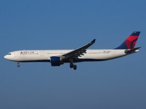 Delta Flight Makes Emergency Landing In Paris After Engine Flames And Cabin Power Loss SEO DES: Passengers heard an explosion-like sound from the left engine, saw sparks and flashes, while cabin lights briefly went dark mid-flight SOCIAL: A Delta Air Lines Airbus A330-300 flying from New York to Milan made an emergency landing in Paris after passengers heard a loud bang from the engine, saw flashes or flames outside the aircraft, and experienced a brief cabin power loss. The crew declared an emergency over France and diverted safely to Charles de Gaulle Airport, where fire and rescue teams were waiting. No injuries were reported, and the aircraft was later grounded for technical inspection following the suspected engine-related malfunction. Paris, France: A Delta Air Lines Airbus A330-300 operating a transatlantic service from New York to Milan made an emergency landing in Paris after passengers reported hearing a loud bang from one of the aircraft’s engines, followed by visible flames outside the cabin and a temporary loss of electrical power. The incident involved Delta Flight DL286, which departed John F. Kennedy International Airport on the afternoon of May 18 for a scheduled overnight flight to Milan Malpensa Airport aboard an 18-year-old Airbus A330-300. The aircraft had crossed the Atlantic normally and was cruising over French airspace early on May 19 when passengers and crew experienced what was described as a sudden “explosion-like” sound from the left engine area. Several passengers later said they observed sparks or flashes from the engine, while others reported the cabin briefly went dark as electrical power fluctuated onboard. Flight tracking data showed the aircraft abruptly altered course and declared an emergency using squawk code 7700 before diverting toward Charles de Gaulle Airport. Emergency vehicles, including airport fire and rescue crews, were positioned alongside the runway as the widebody jet approached Paris. The Airbus landed safely at CDG without further incident. No injuries among passengers or crew were immediately reported. Passengers onboard later described a tense but controlled atmosphere inside the cabin. One traveler wrote online that “the lights went out and the flight attendants booked it to the front of the plane,” while another passenger claimed people seated on the left side of the aircraft could see what appeared to be an engine fire. Others praised the crew for remaining calm and reassuring passengers throughout the diversion and landing. The aircraft involved in the incident was identified as a Delta Airbus A330-323 registered N818NW. The jet had departed JFK at approximately 4:28 PM EDT and diverted into Paris roughly six hours later after the crew declared the emergency over France. While the exact technical cause has not yet been officially confirmed, early reports indicate the crew responded to an engine-related malfunction accompanied by an electrical disturbance affecting cabin systems. Following the landing, the aircraft was removed from service for inspection by maintenance personnel and aviation authorities. Delta Air Lines had not released a detailed technical statement at the time of publication.