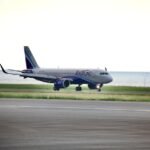 New Delhi, India: InterGlobe Aviation, the parent company of India’s largest airline, IndiGo, reported a consolidated net loss of ₹2,536.9 crore for the quarter ended March 31, 2026 (Q4 FY26), reversing from a net profit of ₹3,067.5 crore recorded during the corresponding quarter of the previous financial year. The sharp decline in profitability came amid significant foreign exchange losses, elevated fuel prices, operational disruptions, and one-time charges that weighed heavily on the carrier’s financial performance despite a marginal increase in revenue. According to the airline’s financial results, revenue from operations rose 1.3% year-on-year to ₹22,438 crore in the January-March 2026 quarter, compared with ₹22,152 crore in Q4 FY25. However, the increase in revenue was insufficient to offset mounting cost pressures. A major factor behind the quarterly loss was a foreign exchange loss of approximately ₹4,823 crore, driven by the depreciation of the Indian rupee against the US dollar. The impact was particularly significant for IndiGo as a large portion of its expenses including aircraft leases, maintenance costs and other aviation-related payments are dollar-denominated. The airline also faced rising aviation turbine fuel (ATF) costs during the quarter amid geopolitical tensions and higher crude oil prices. Fuel remains one of the largest expense components for airlines and contributed substantially to the pressure on margins. In addition, IndiGo reported a one-time charge of ₹250 crore during the quarter. The airline also continued to face operational challenges, including disruptions linked to airspace restrictions and capacity-related constraints that affected network efficiency. Despite the reported loss, the company stated that its underlying business performance remained profitable. Excluding the impact of foreign exchange fluctuations and exceptional items, IndiGo posted a net profit of approximately ₹1,921 crore during the quarter. For the full financial year ended March 31, 2026, IndiGo reported a consolidated net loss of around ₹2,394 crore. The company’s annual results were affected by foreign exchange losses of nearly ₹8,100 crore, disruption-related costs estimated at about ₹580 crore, and expenses of roughly ₹1,200 crore associated with the implementation of new labour regulations. At the operational level, IndiGo carried approximately 123.4 million passengers during FY26, representing a 4% increase compared with the previous year. Total income for the fiscal year rose 6.4% to ₹89,513 crore, reflecting continued demand growth in India’s aviation sector despite a challenging operating environment. The airline’s board also approved the partial prepayment of finance lease obligations owed to its wholly-owned subsidiary, InterGlobe Aviation Financial Services IFSC Private Limited. The prepayment, to be executed in one or more tranches, may total up to US$450 million and is intended to support future aircraft and aviation asset acquisitions. Management indicated that IndiGo is evaluating fuel hedging strategies after remaining largely unhedged during a period of heightened volatility in crude oil prices. The airline said such measures could help reduce exposure to future fuel price fluctuations. Looking ahead, IndiGo expects capacity growth to moderate in the near term. The airline has guided for capacity expansion of approximately 3-4% in the first quarter of FY27, significantly lower than the 16.4% growth recorded during the corresponding period a year earlier. Following the earnings announcement, market participants indicated that IndiGo shares would remain in focus as investors assess the impact of currency movements, fuel costs, regulatory developments and operational performance on the airline’s future profitability.