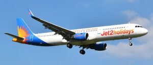 Porto, Portugal: A Jet2 passenger flight travelling from Tenerife, Spain, to Birmingham, United Kingdom, was forced to make an emergency diversion to Portugal after one of the pilots suffered a serious medical emergency while the aircraft was cruising at approximately 30,000 feet. The incident involved Jet2 Flight LS1266, operated by an Airbus A321, carrying around 220 passengers and crew. The aircraft departed Tenerife late on May 21 and was en route to Birmingham when the cockpit emergency unfolded during the early hours of May 22. Several passengers later described scenes of panic onboard after the cabin crew suddenly rushed through the cabin asking whether any doctors or medically trained passengers were onboard. According to passengers flashing cabin lights and the rapid descent of the aircraft woke sleeping travellers. Families travelling with children described distress inside the cabin, with several passengers reporting that crying babies and panic among travellers added to the tense atmosphere during the emergency diversion. Some passengers alleged that cabin crew appeared visibly distressed while attempting to assist the incapacitated pilot. The First Officer reportedly took immediate control of the aircraft after the captain became incapacitated. The Airbus A321 then diverted toward Porto’s Francisco Sá Carneiro Airport, where emergency medical teams were already positioned on the runway before landing. The aircraft touched down safely at approximately 2:11 a.m. local time. Medical responders boarded the aircraft immediately after arrival and transported the affected pilot to a nearby hospital for treatment. While several passenger accounts stated that the pilot suffered a heart attack, Jet2 has not officially confirmed the exact medical condition. The airline only stated that one of the pilots became “unwell” during the flight and emphasized that “at no point was safety compromised.” Passengers were reportedly left stranded in Portugal for more than 13 hours following the emergency landing. Some travellers complained about delays in disembarkation, lack of immediate accommodation and limited communication regarding onward travel arrangements. Jet2 later dispatched a replacement pilot from Manchester to continue the journey to Birmingham.