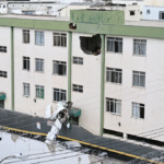 Belo Horizonte, Brazil: A small twin-engine aircraft crashed into a residential building in the Silveira neighbourhood of Belo Horizonte on Monday, killing three of the five people onboard and injuring two others, according to Brazilian authorities. The aircraft, identified as an Embraer EMB-721C, departed from Pampulha Airport at approximately 12:16 p.m. local time, bound for São Paulo. Within minutes of takeoff, the aircraft began experiencing difficulties and remained airborne for only a short duration before losing altitude. It ultimately crashed around 12:25 p.m. into a three-storey residential building, striking a stairwell area between floors, which helped prevent casualties among residents. Authorities confirmed that three occupants died in the crash. The victims include pilot Wellington Oliveira and passenger Fernando Moreira Souto, who was the son of the mayor of Jequitinhonha. Souto was initially rescued in critical condition but later succumbed to his injuries in hospital. The co-pilot also died, though their identity has not been officially released in primary reports. Two other passengers survived the crash and were taken to hospital, where they are reported to be in stable condition. Eyewitness accounts and initial footage indicate that the aircraft appeared to be circling and descending abnormally before impact, suggesting a possible loss of power or control shortly after departure. Despite the direct collision with the building, no residents on the ground were injured, and structural damage was limited, avoiding a potentially larger disaster. Emergency responders, including firefighters, medical teams and civil defence personnel, reached the crash site within minutes. Residents of the building were evacuated as a precaution while authorities secured the area and assisted survivors. The cause of the crash remains under investigation. Brazil’s Aeronautical Accidents Investigation and Prevention Center (CENIPA), along with regional unit SERIPA III and the Civil Police of Minas Gerais, have launched a formal probe. Investigators are examining possible mechanical issues, operational factors and the aircraft’s condition. In response to the incident, officials in Jequitinhonha declared three days of mourning following the death of Fernando Moreira Souto. Authorities have not yet released a final determination on what led to the crash, and investigations are ongoing.