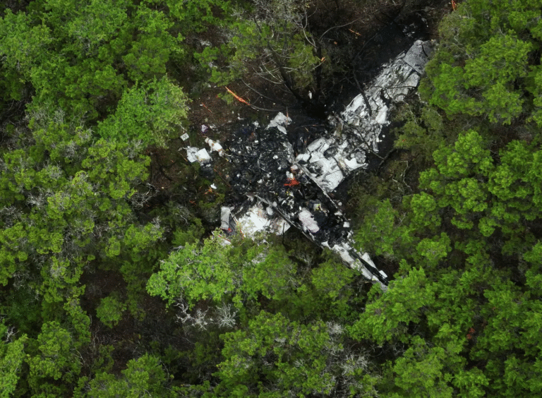 Hays County, United States: A late-night aviation tragedy in Texas Hill Country has left five people dead after a twin-engine aircraft crashed near Wimberley in Hays County on April 30, 2026. According to local authorities and federal officials, the aircraft identified as a Cessna 421C went down at approximately 11:00 p.m. in a wooded area off Round Rock Road, triggering an immediate emergency response from fire and rescue crews. All five occupants onboard, including the pilot and four passengers, were pronounced dead at the scene. Flight tracking data indicates the aircraft was traveling from Amarillo to New Braunfels when it encountered trouble during the latter phase of the journey. Data shows the aircraft made a sudden sharp turn before entering a rapid descent, dropping from approximately 13,600 feet to around 7,000 feet within a short span. Radar contact was lost shortly thereafter. Officials said the aircraft impacted the ground at a high rate of speed, suggesting a catastrophic loss of control prior to the crash. Residents in the area reported hearing a loud explosion-like sound, followed by vibrations and visible flames. Several described seeing a fireball at the crash site moments after impact. Emergency crews were dispatched shortly after 11:05 p.m. and remained at the site through the night and into the following morning to manage the fire and begin recovery operations. Authorities confirmed that another aircraft had been flying along a similar route at the time of the incident. The second aircraft reportedly lost contact with the crashed plane but continued safely and landed in New Braunfels without incident. While the exact cause remains unknown, early reports indicate there may have been thunderstorm activity in the region at the time of the crash. Investigators have not confirmed whether weather played a direct role. No evidence has emerged to suggest a mid-air collision. The aircraft involved was a Cessna 421C, a pressurized, twin-engine aircraft commonly used for private and business travel. The Federal Aviation Administration (FAA) and the National Transportation Safety Board (NTSB) have launched a formal investigation. A preliminary report is expected within weeks, while the final report could take up to one to two years.